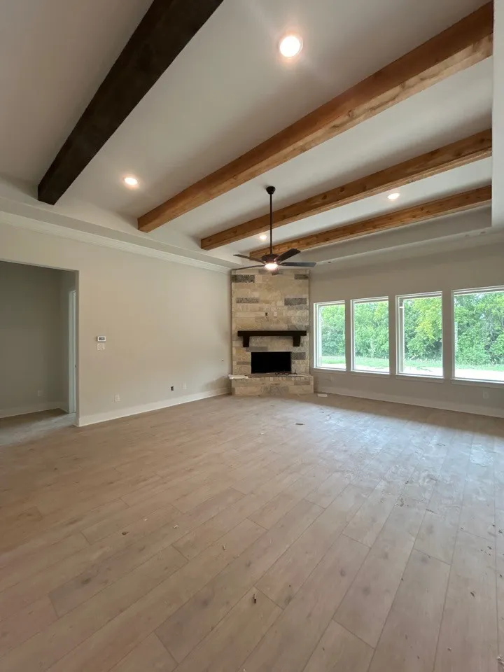 Vaulted ceiling with exposed wood beams, recessed lighting, and a ceiling fan