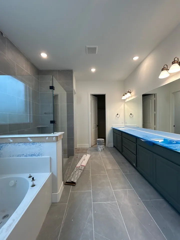 Walk-in shower with glass enclosure, separate soaking tub, dual vanity with cabinet storage, tiled flooring, and recessed lighting