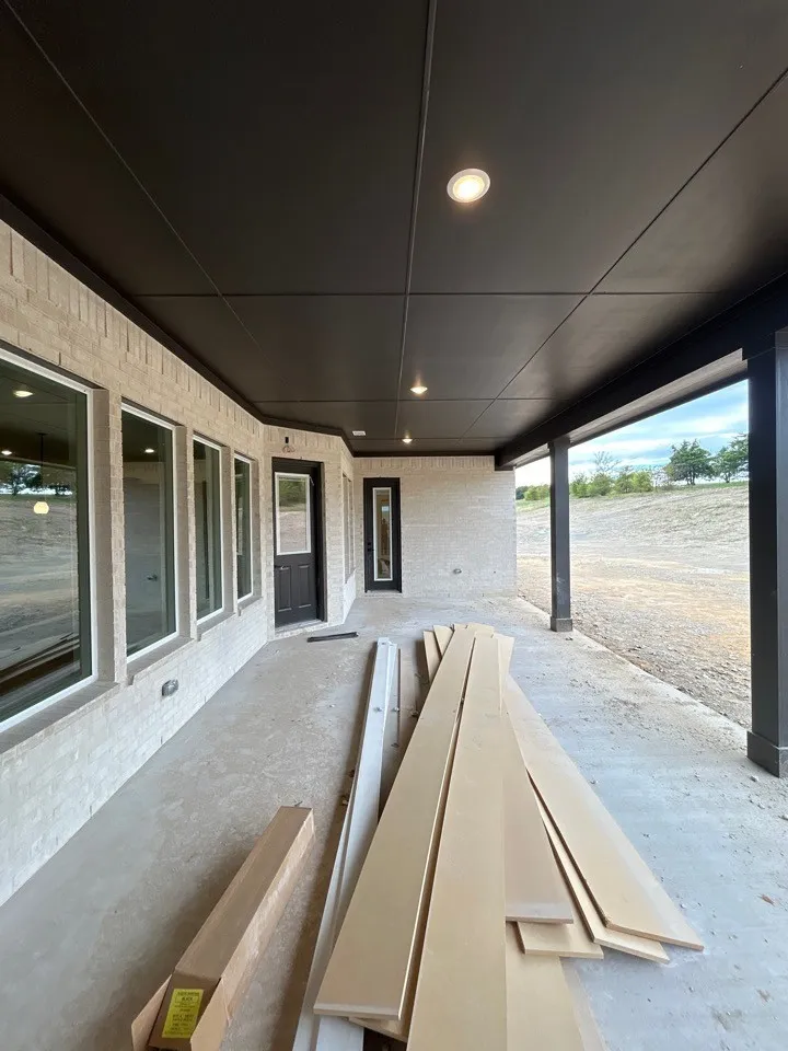 Covered patio with a light-colored brick exterior, recessed lighting, concrete flooring, and multiple windows