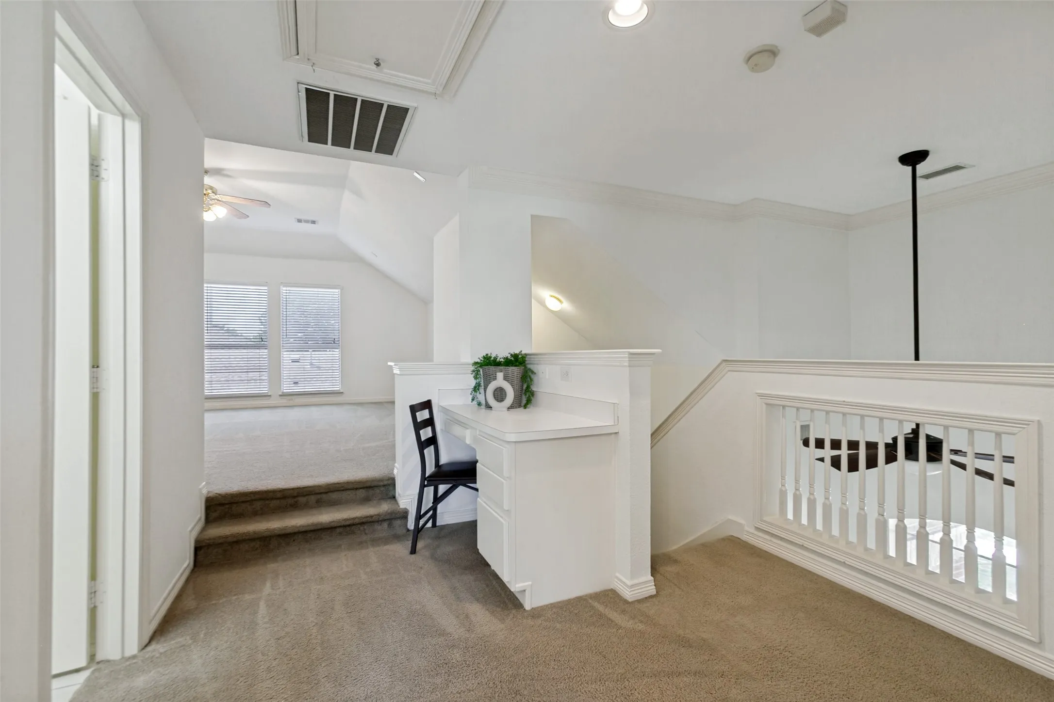 A built in desk is featured at the top of the stairs