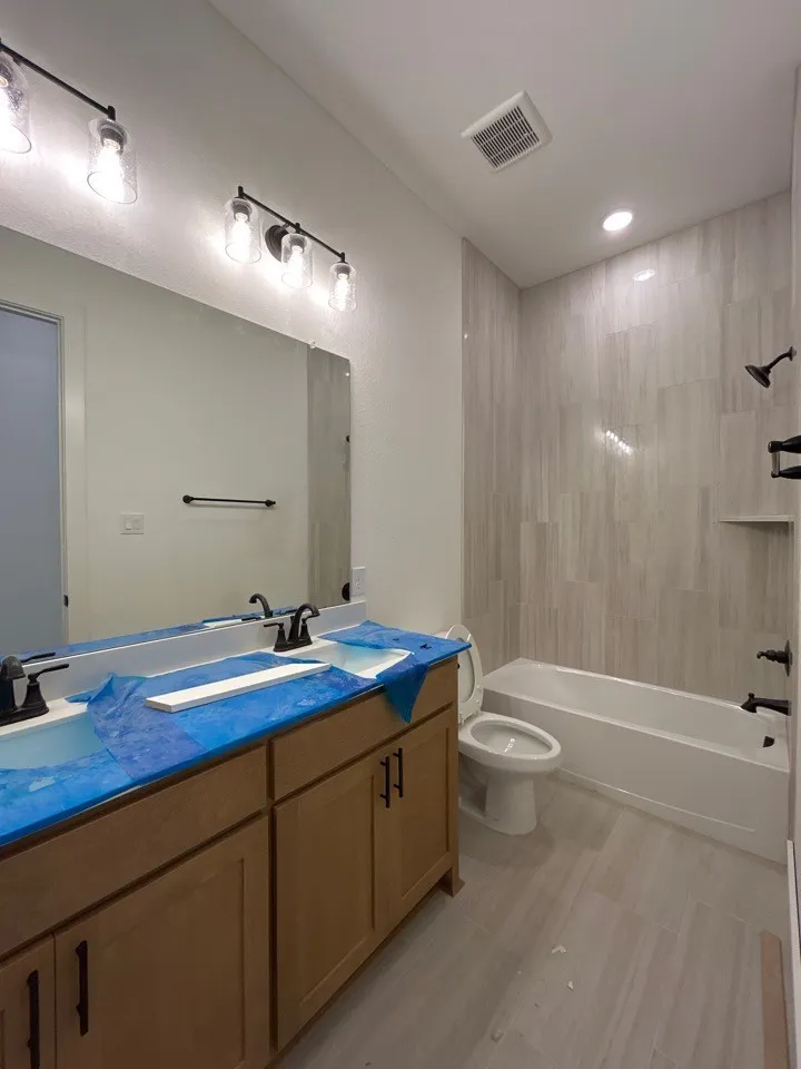 Dual vanity with wood-finish cabinetry and matte black hardware