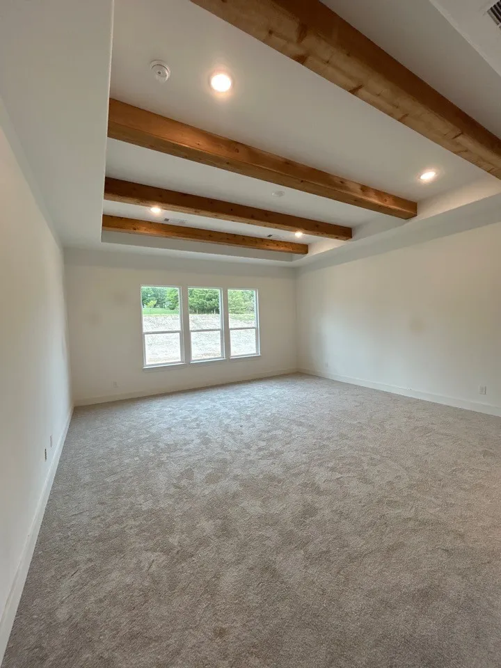 Tray ceiling with wood beams, recessed lighting, expansive windows, and plush carpeting