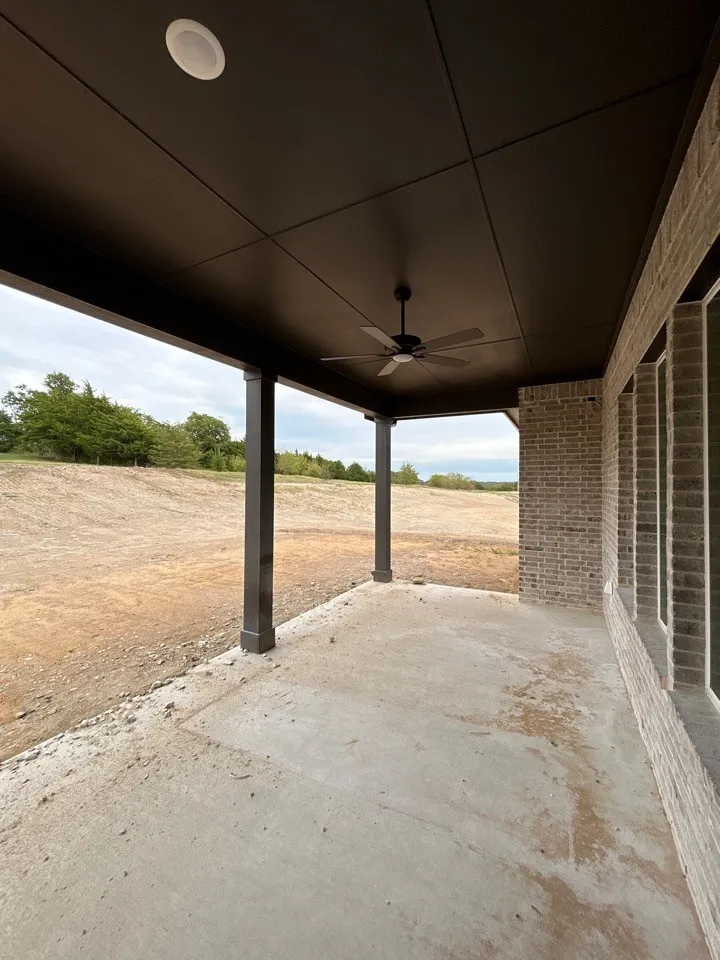 Covered patio with a concrete surface, ceiling fan, recessed lighting, and brick exterior wall