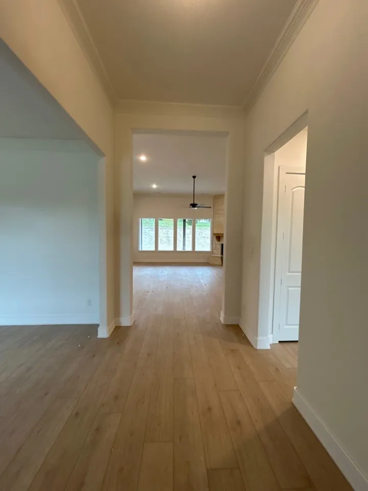 Wood-finish flooring extending through an arched entryway