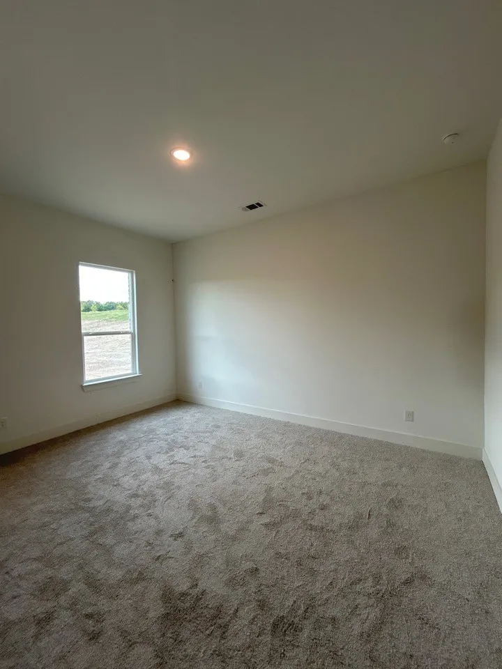 Recessed lighting, neutral wall paint, white trim, and light-toned carpeting