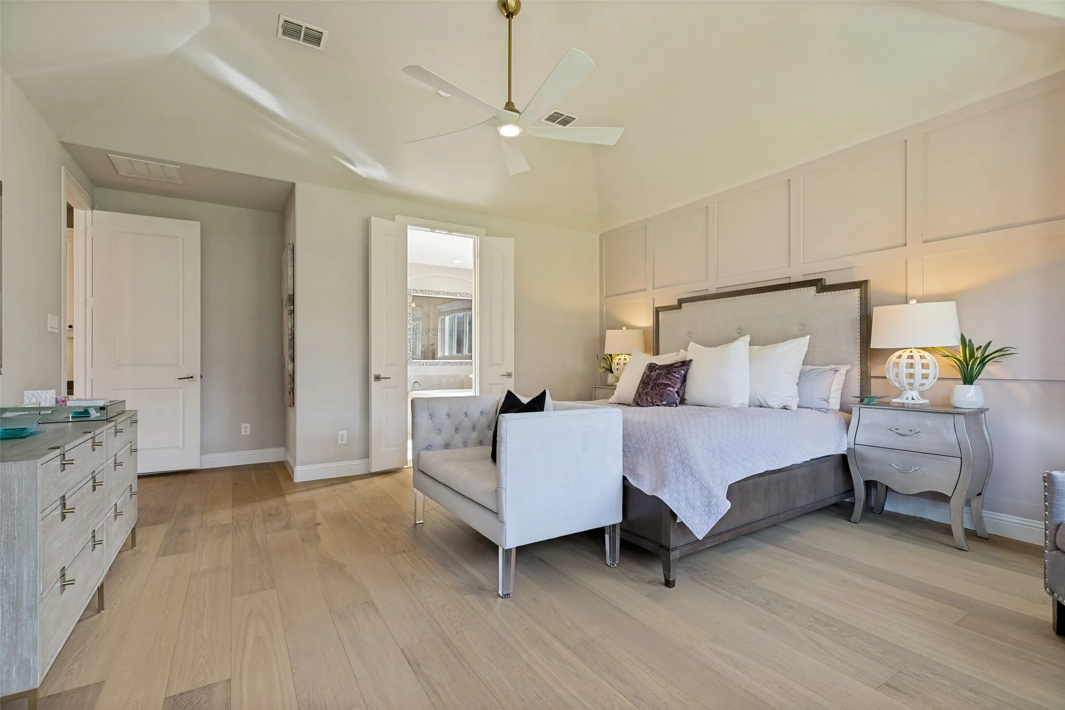 Spacious bedroom featuring wood-finish flooring, a vaulted ceiling, and a ceiling fan