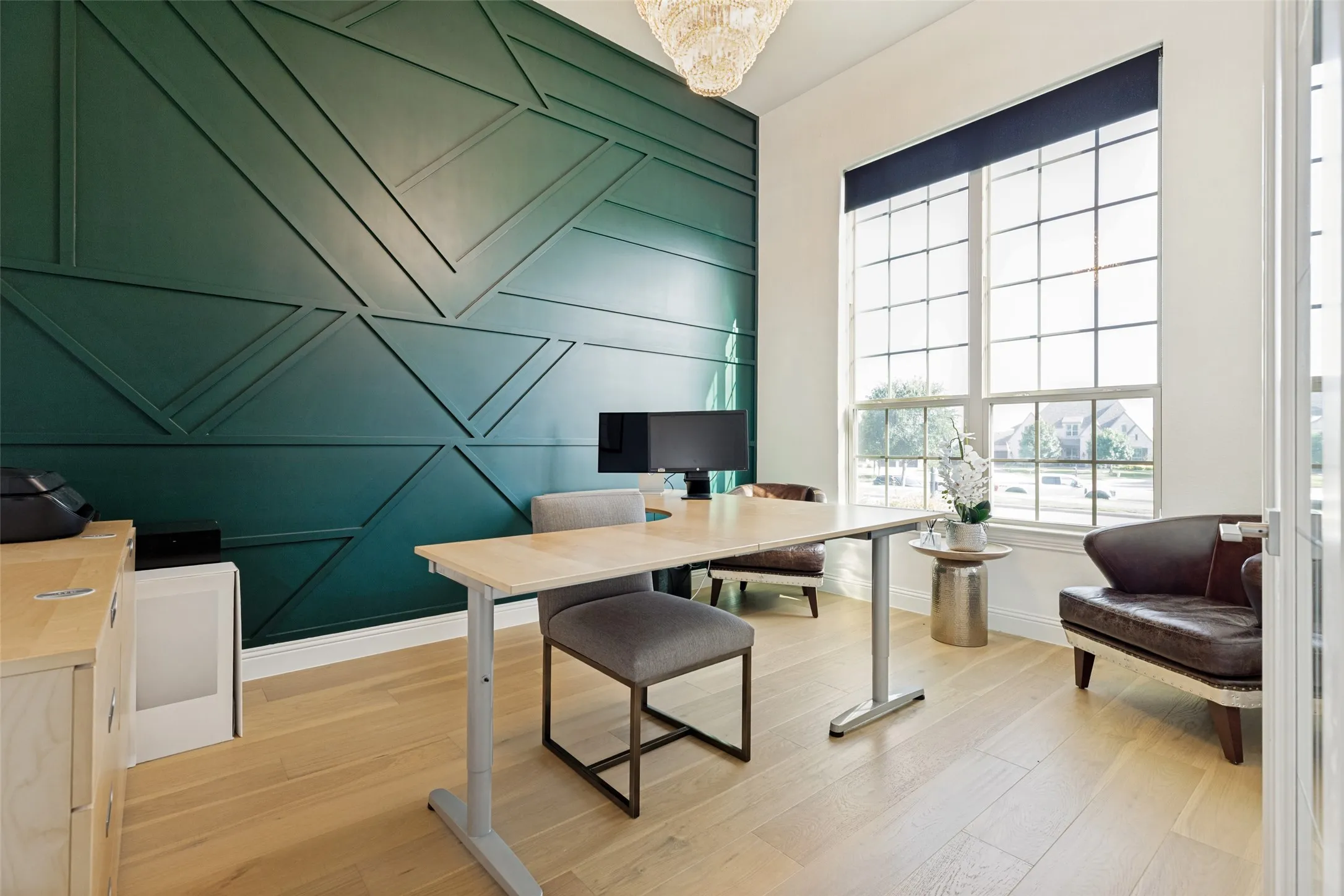 Accent wall featuring geometric panel molding, tall multi-pane windows with roller shades, light wood-finish flooring, and a contemporary ceiling light fixture
