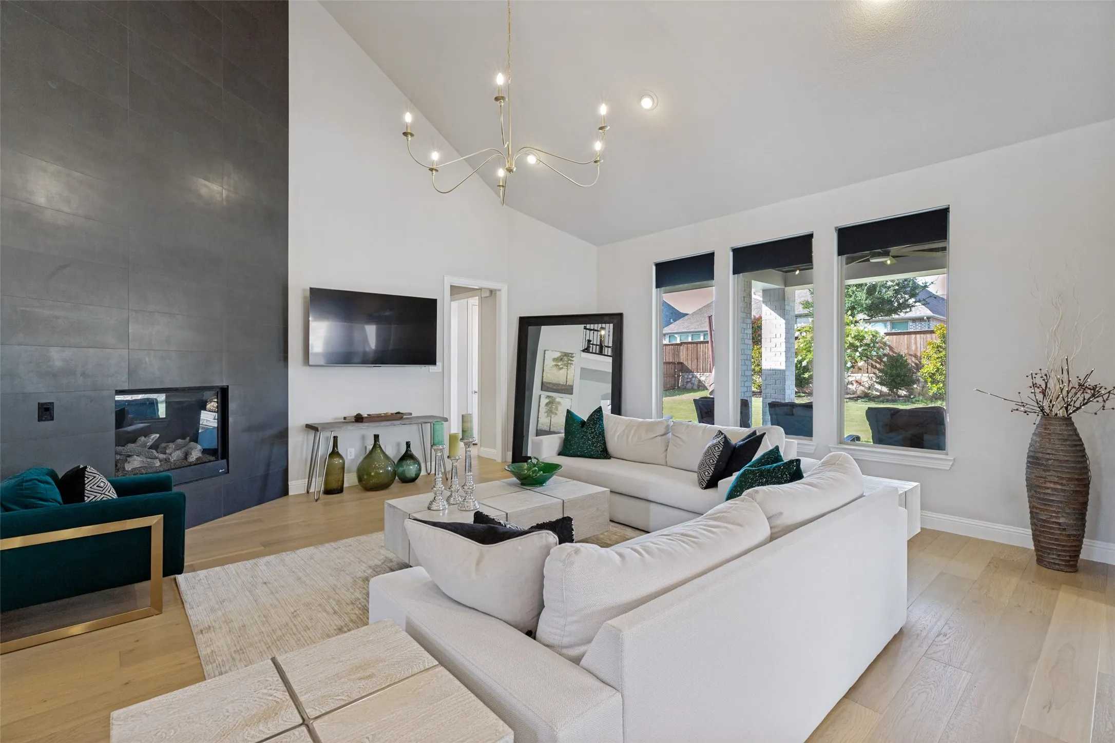 Spacious living area featuring a vaulted ceiling and light wood-finish flooring