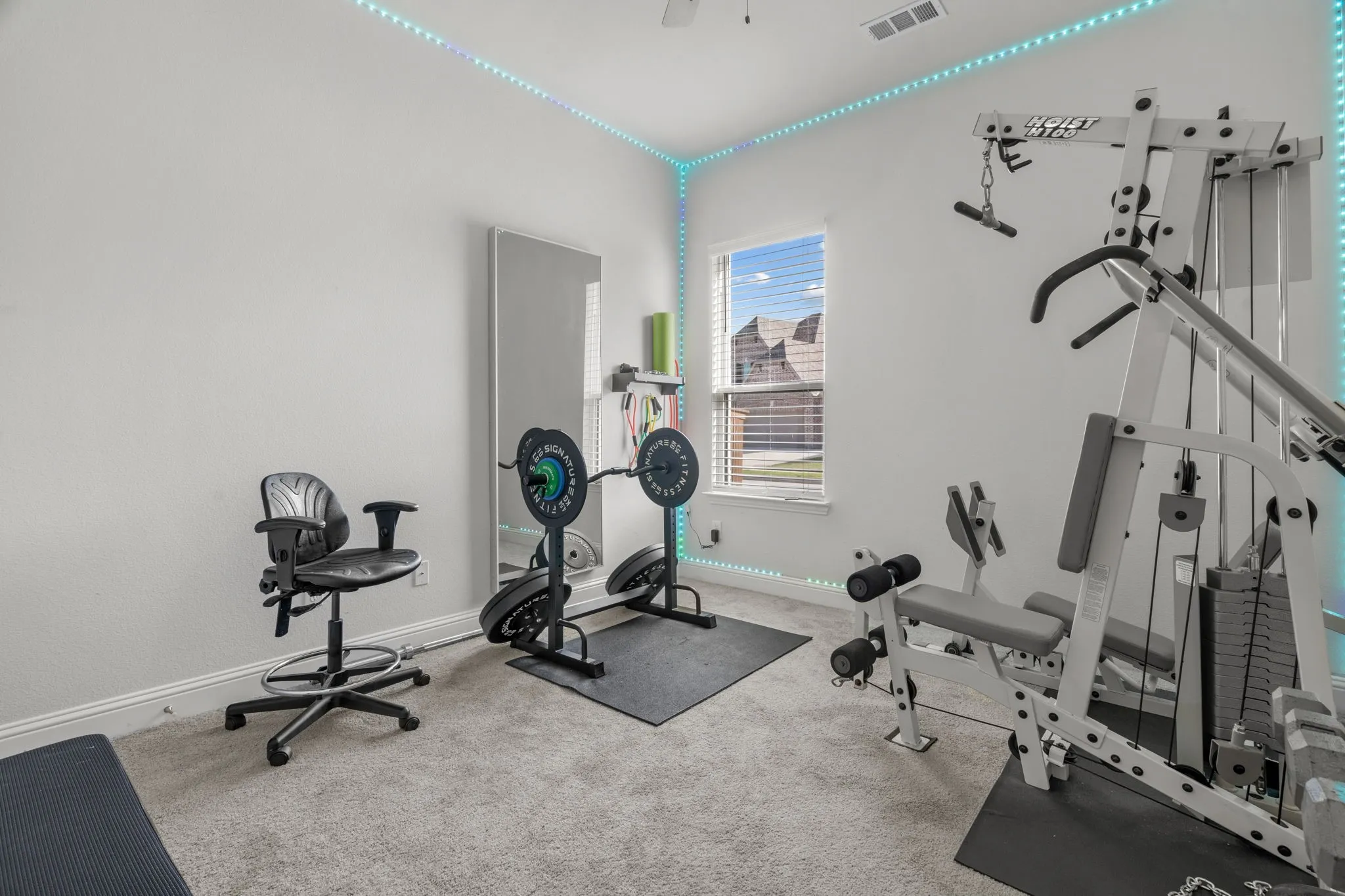 Carpeted room featuring a single window with blinds, white baseboards, and a ceiling fan