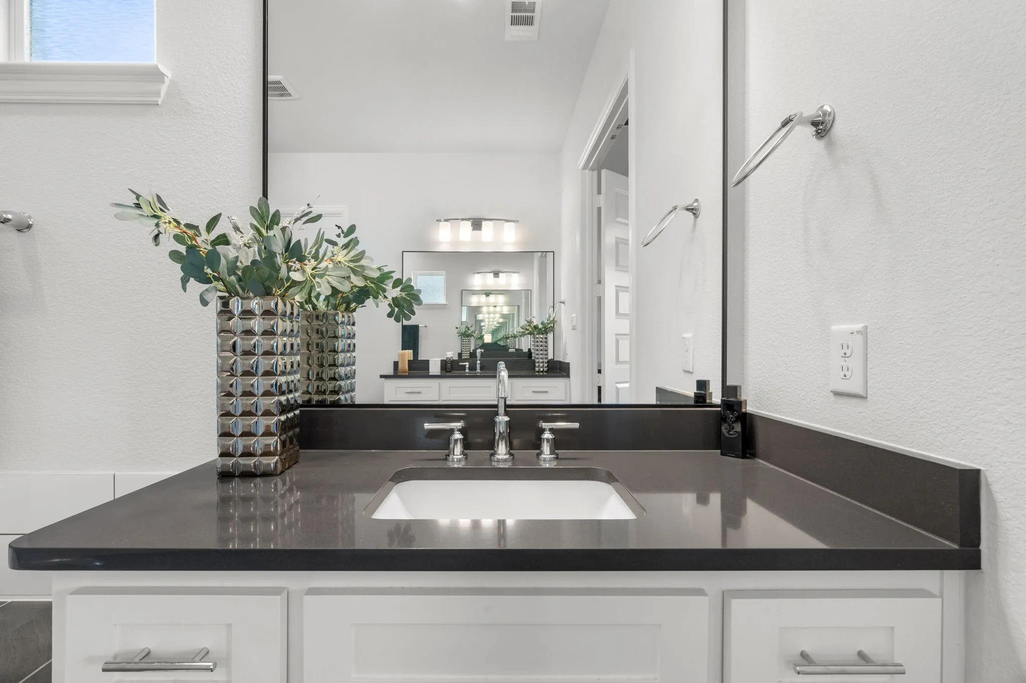 Bathroom vanity featuring a dark countertop with an integrated rectangular sink