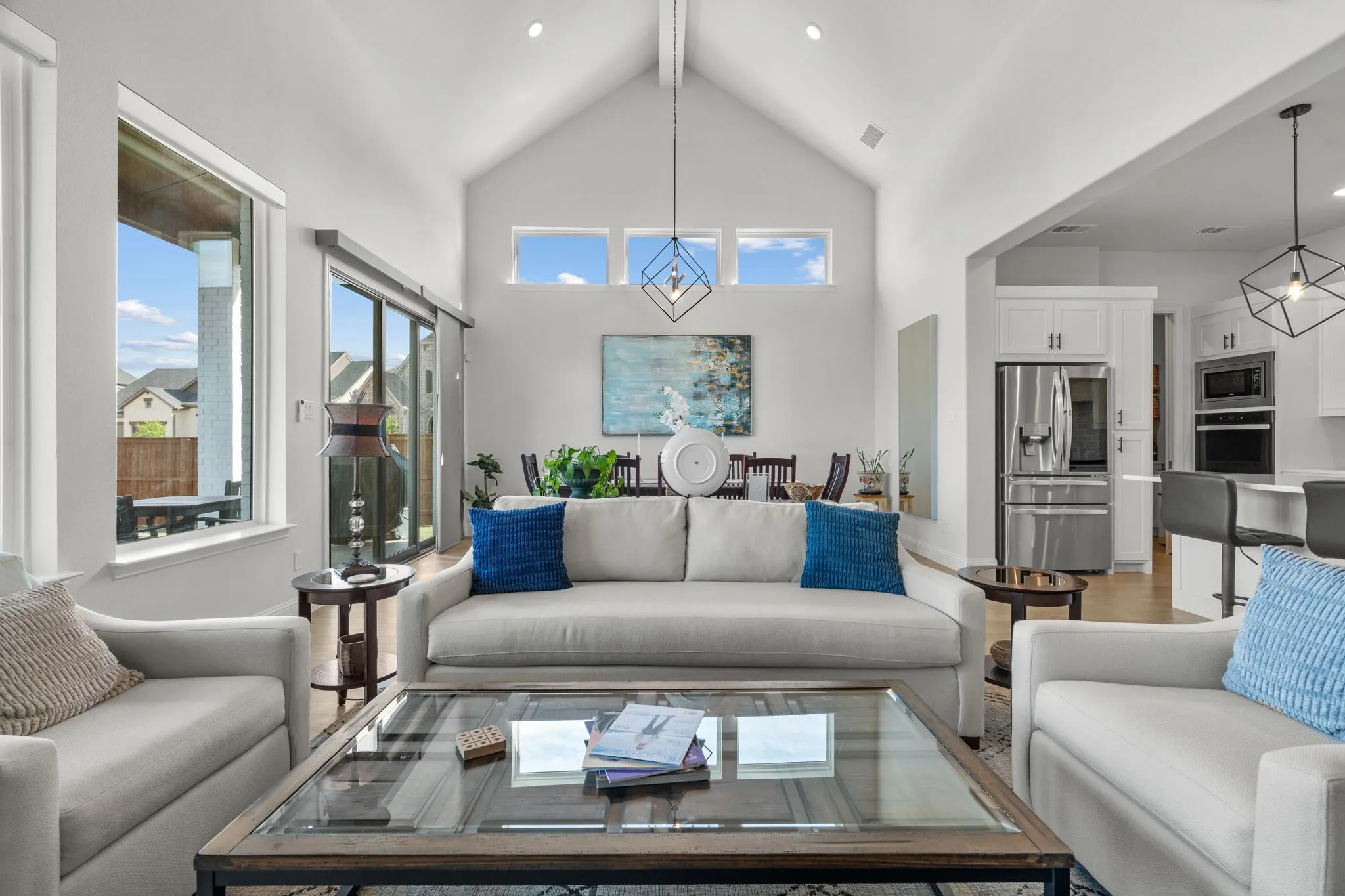 Vaulted ceiling living room featuring a linear chandelier, recessed lighting, and wood-finish flooring