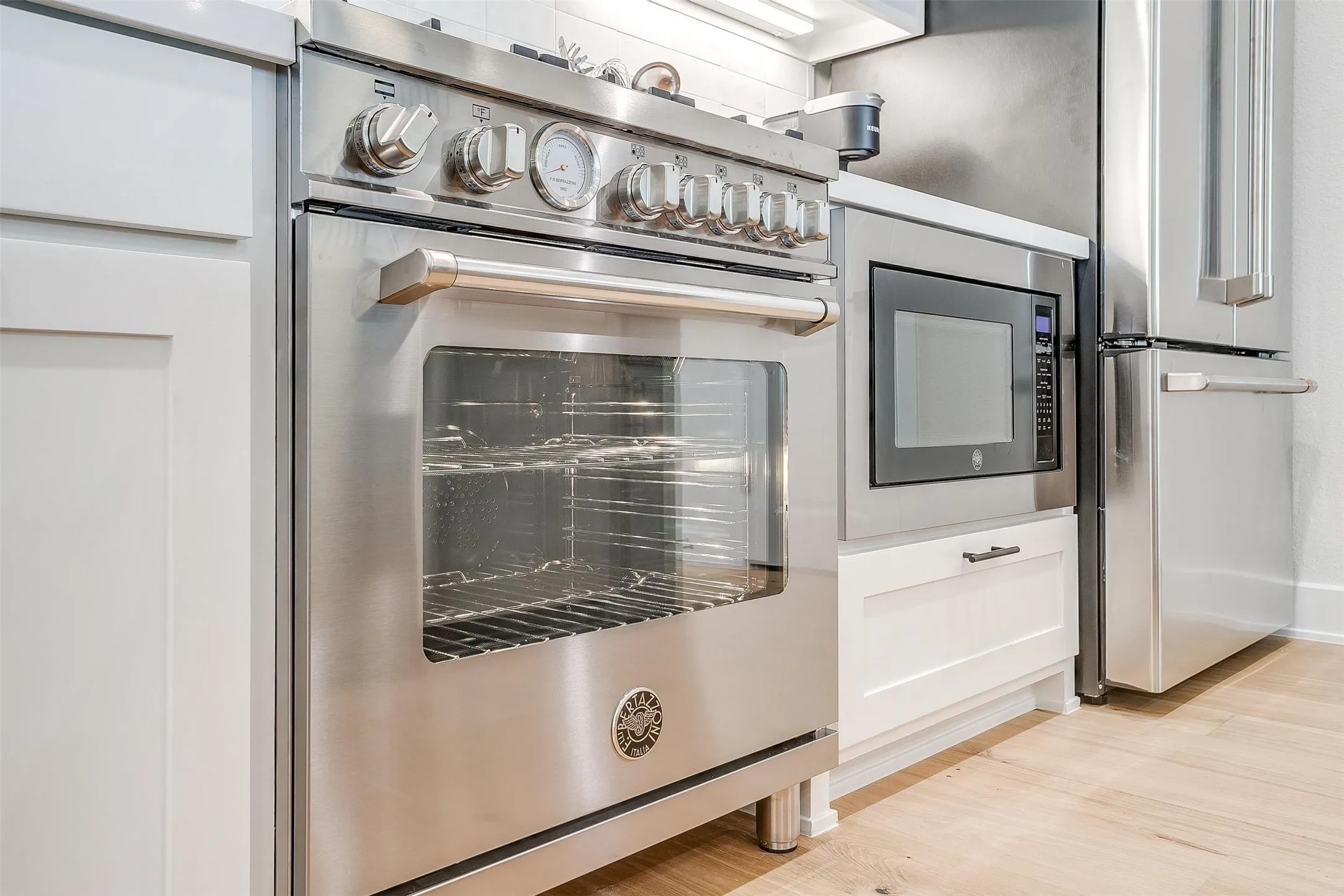 Kitchen with high end appliances and light wood finished floors