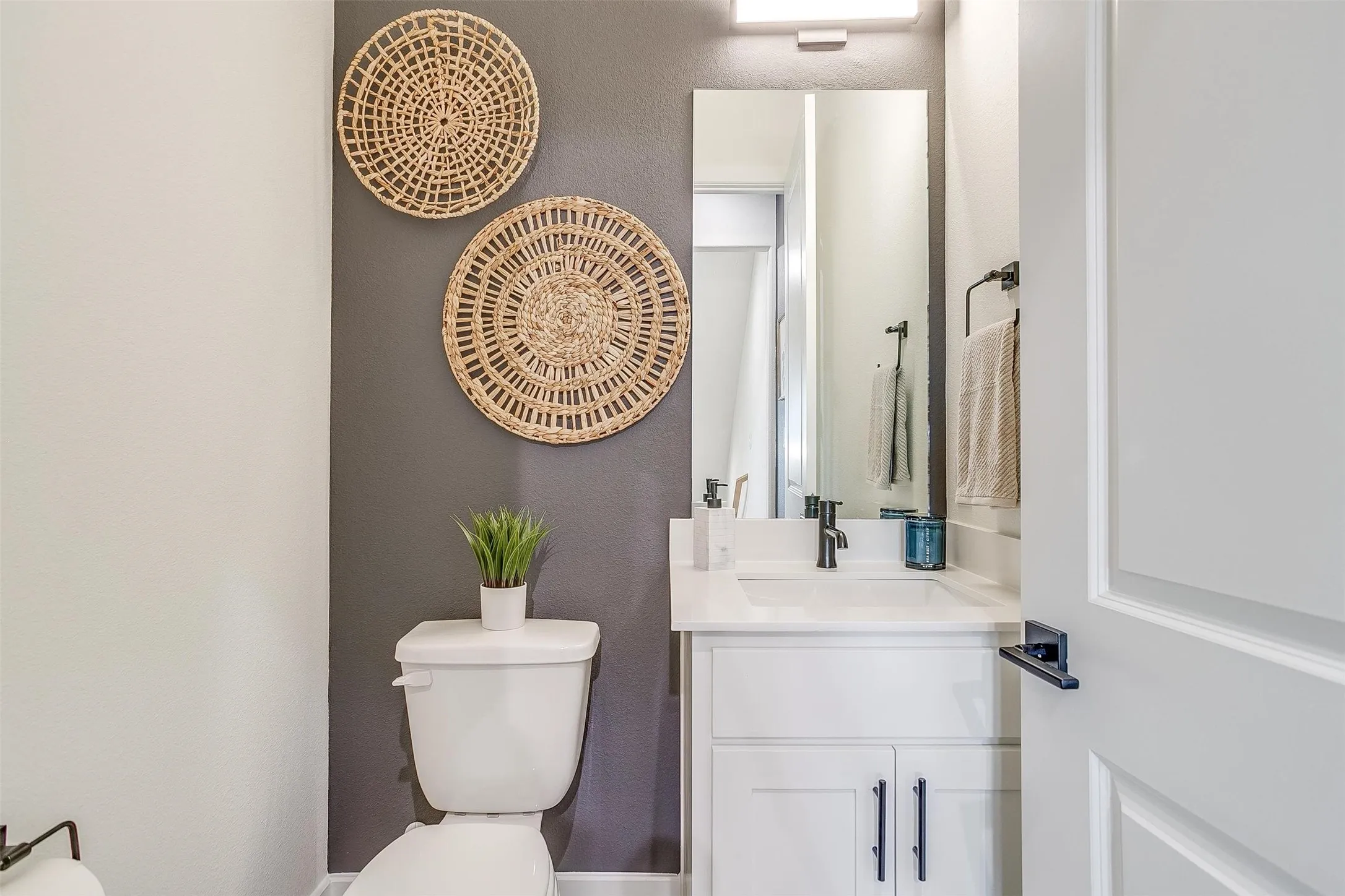Bathroom featuring a textured wall and vanity