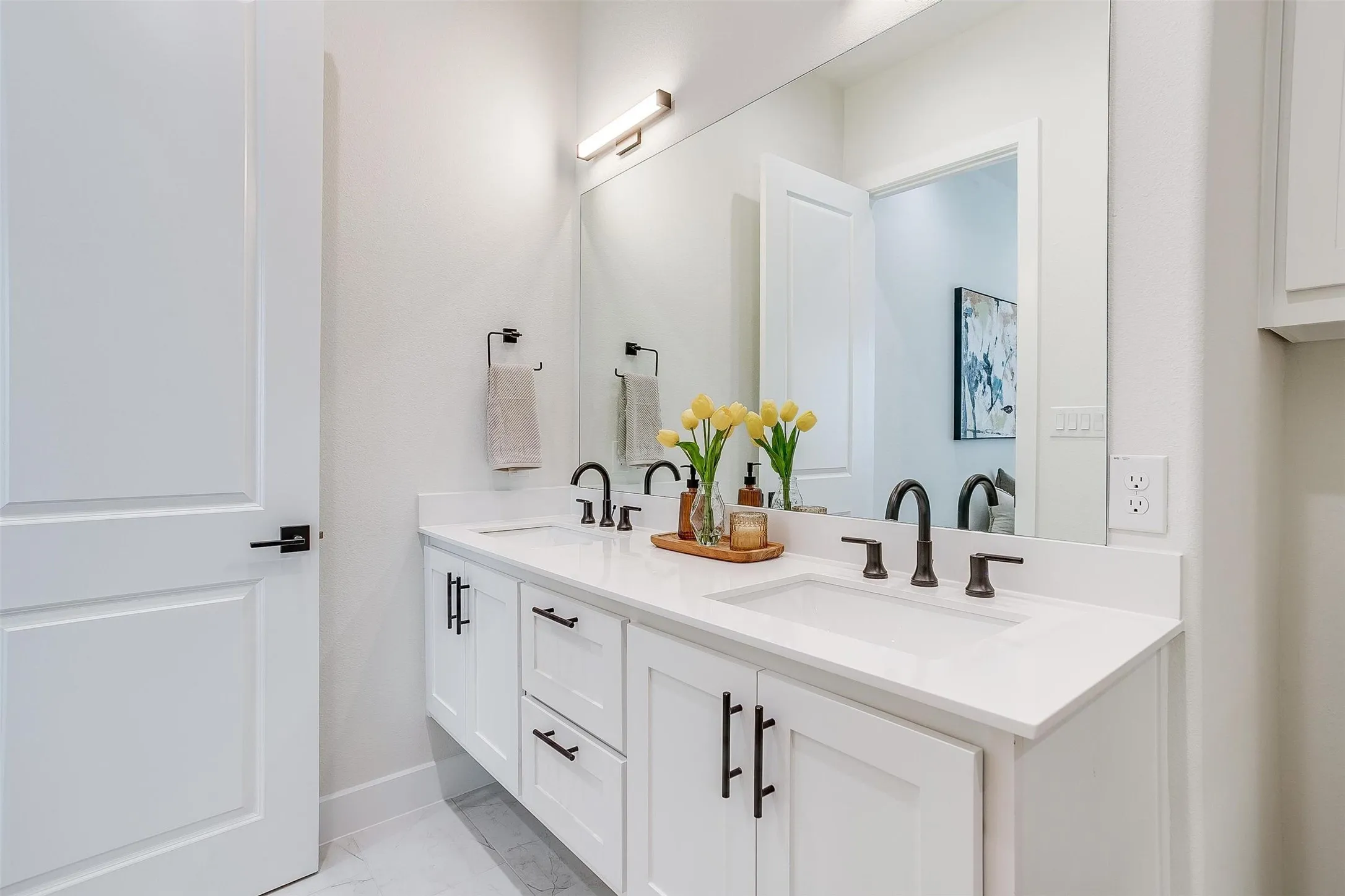 Bathroom featuring double vanity and light marble finish floors