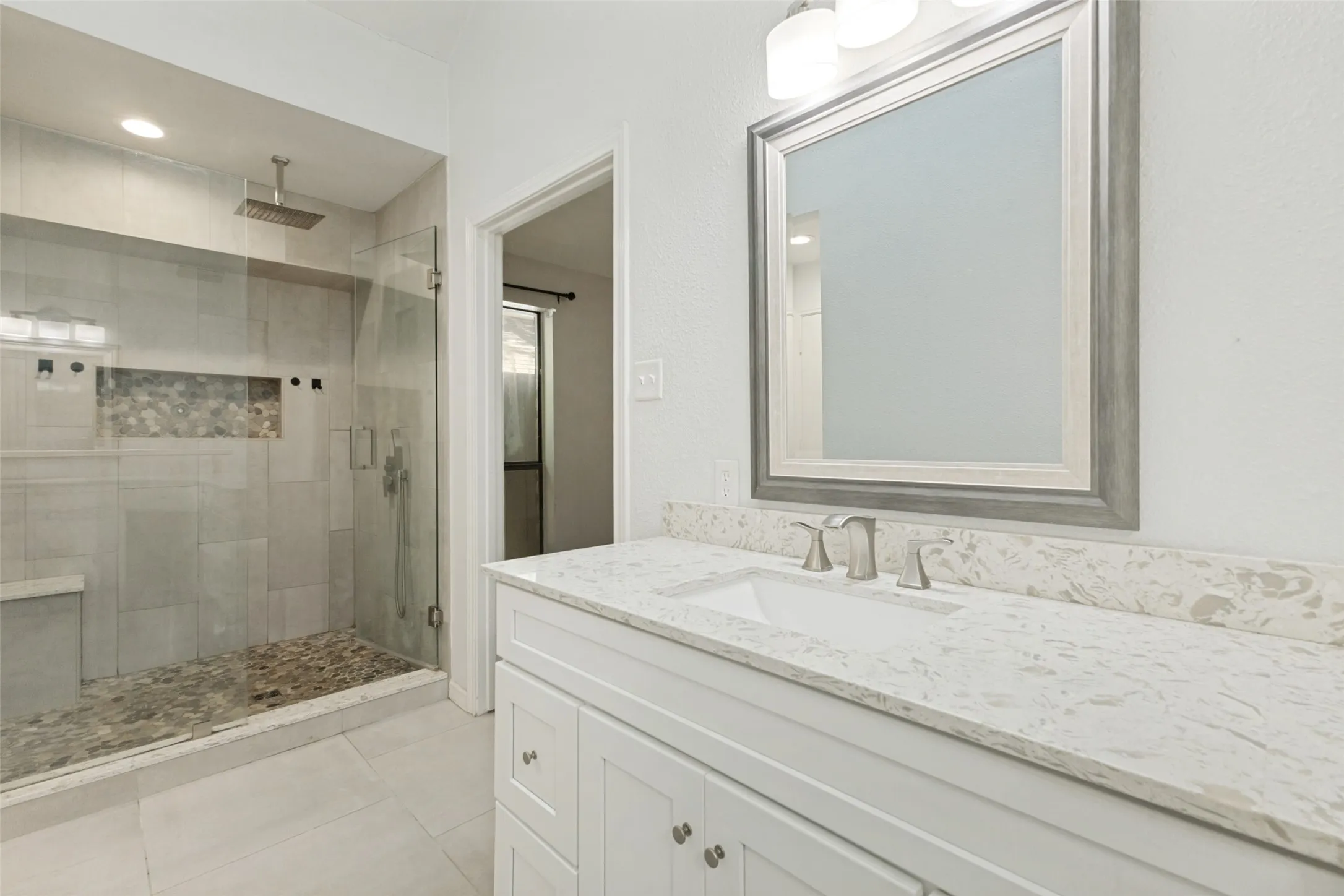 Bathroom featuring a white vanity with an undermount sink, a stone-finish countertop, and brushed nickel fixtures