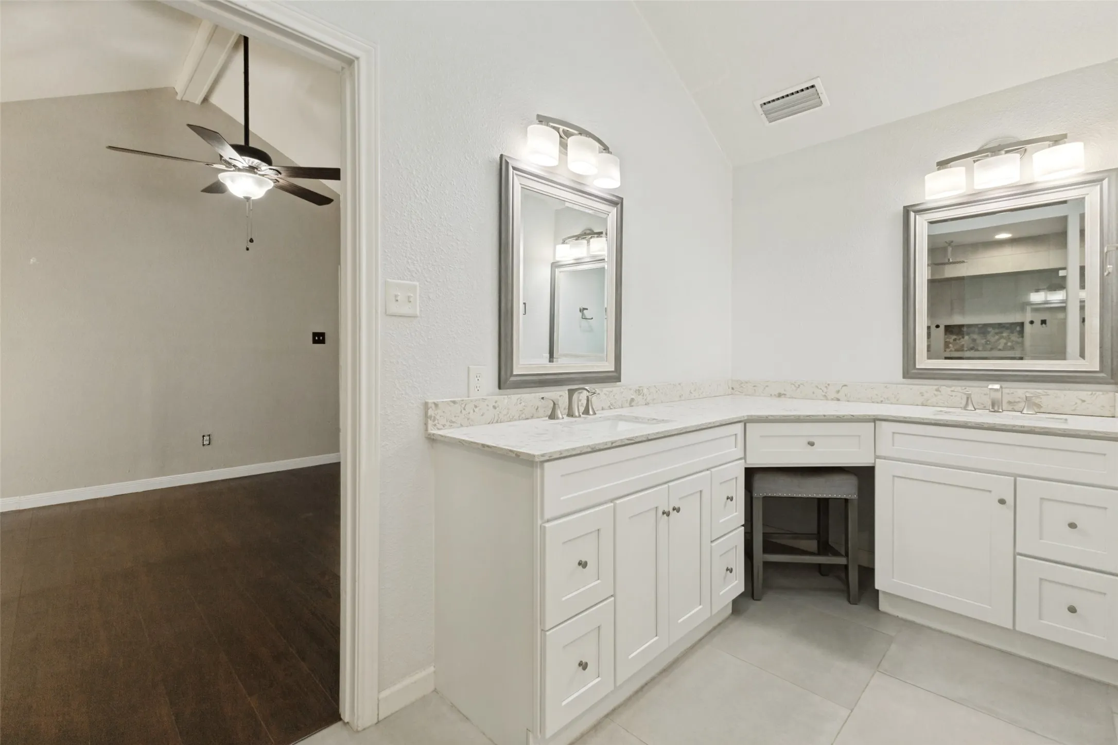 Dual vanity with white cabinetry, light-toned countertops, and brushed nickel hardware