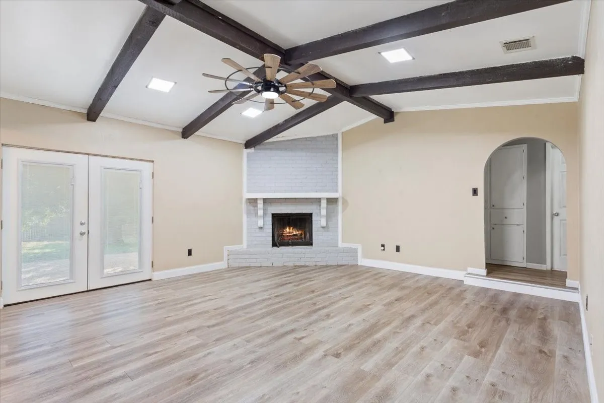 Vaulted ceiling with exposed wood beams and central ceiling fan