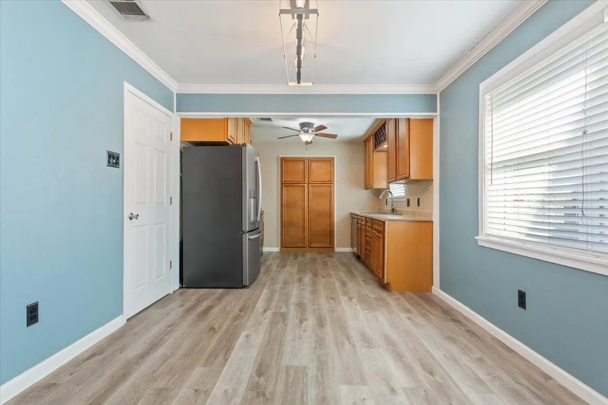 Open-concept dining area with wood-finish flooring and a bright window