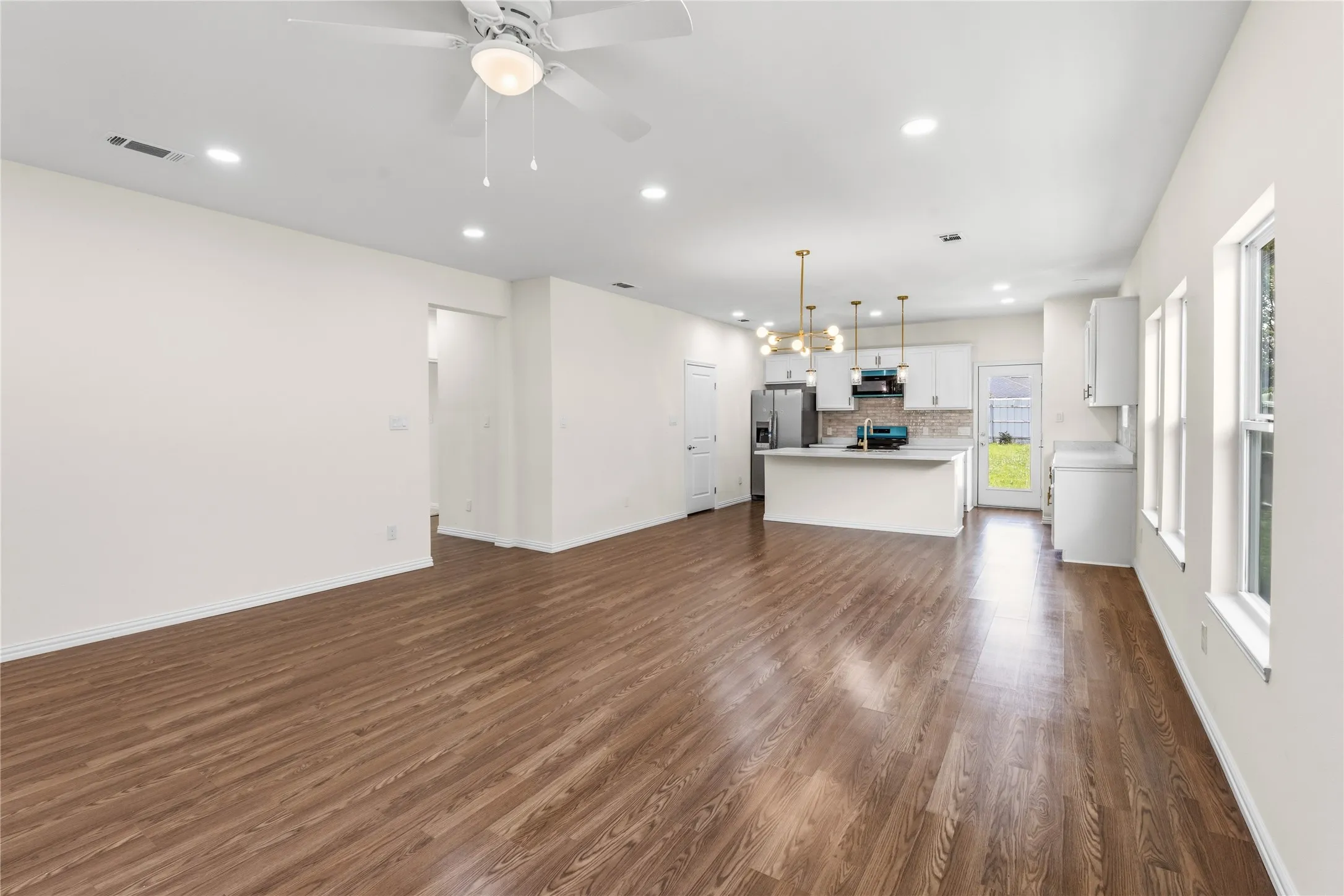 Open-concept living space featuring wood-finish flooring, recessed lighting, and a ceiling fan