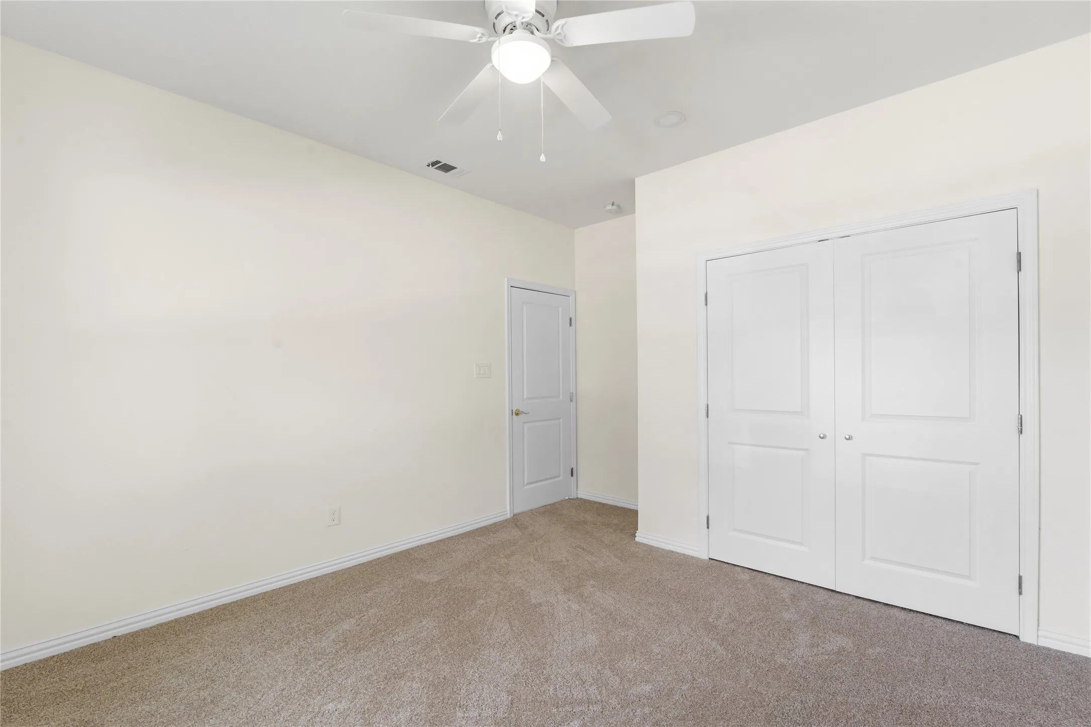 Spacious room featuring neutral carpet flooring and light-toned walls