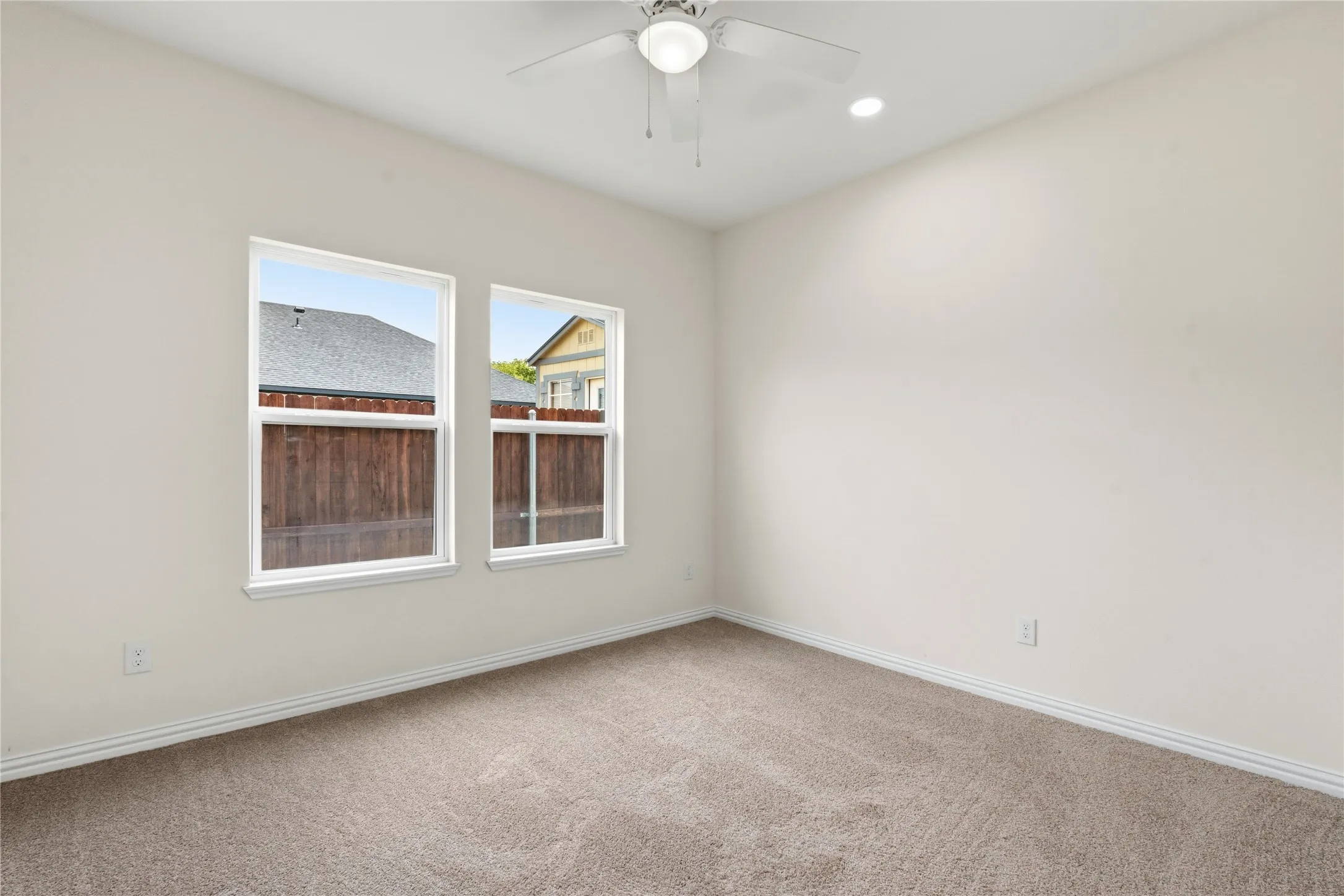 Carpeted room featuring two white-framed windows, a ceiling fan, and recessed​​‌​​​​‌​​‌‌​‌‌​​​‌‌​‌​‌​‌​​​‌​​ lighting