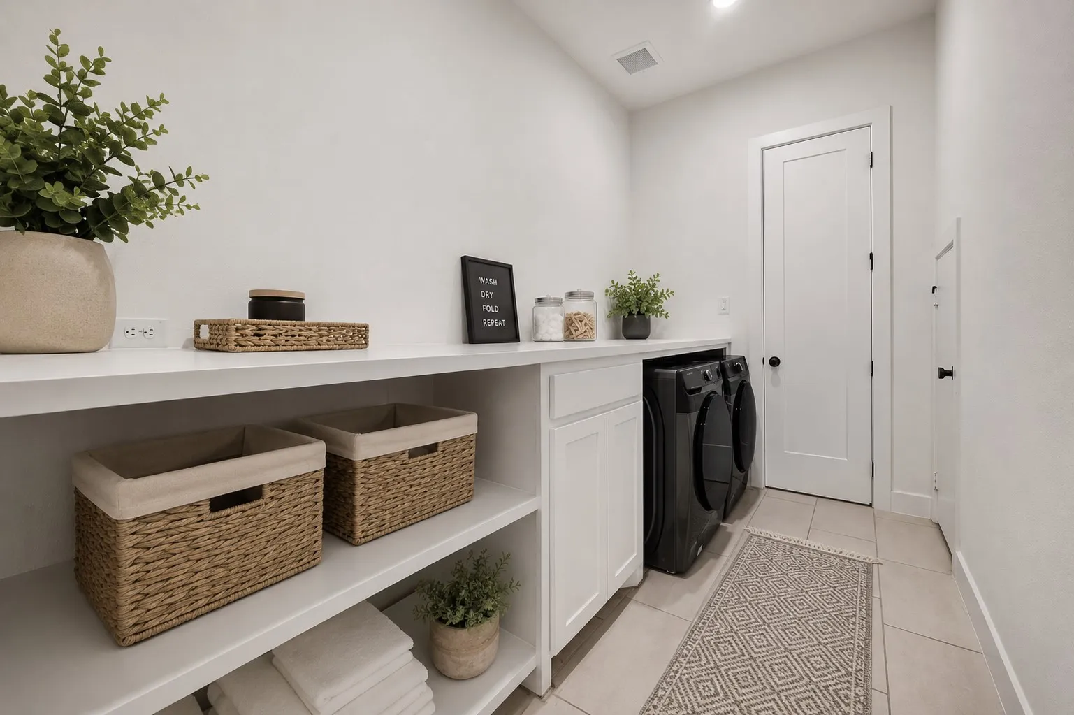 Virtually staged- Dedicated laundry room featuring white cabinetry, integrated countertop space, two built-in appliances, and open shelving