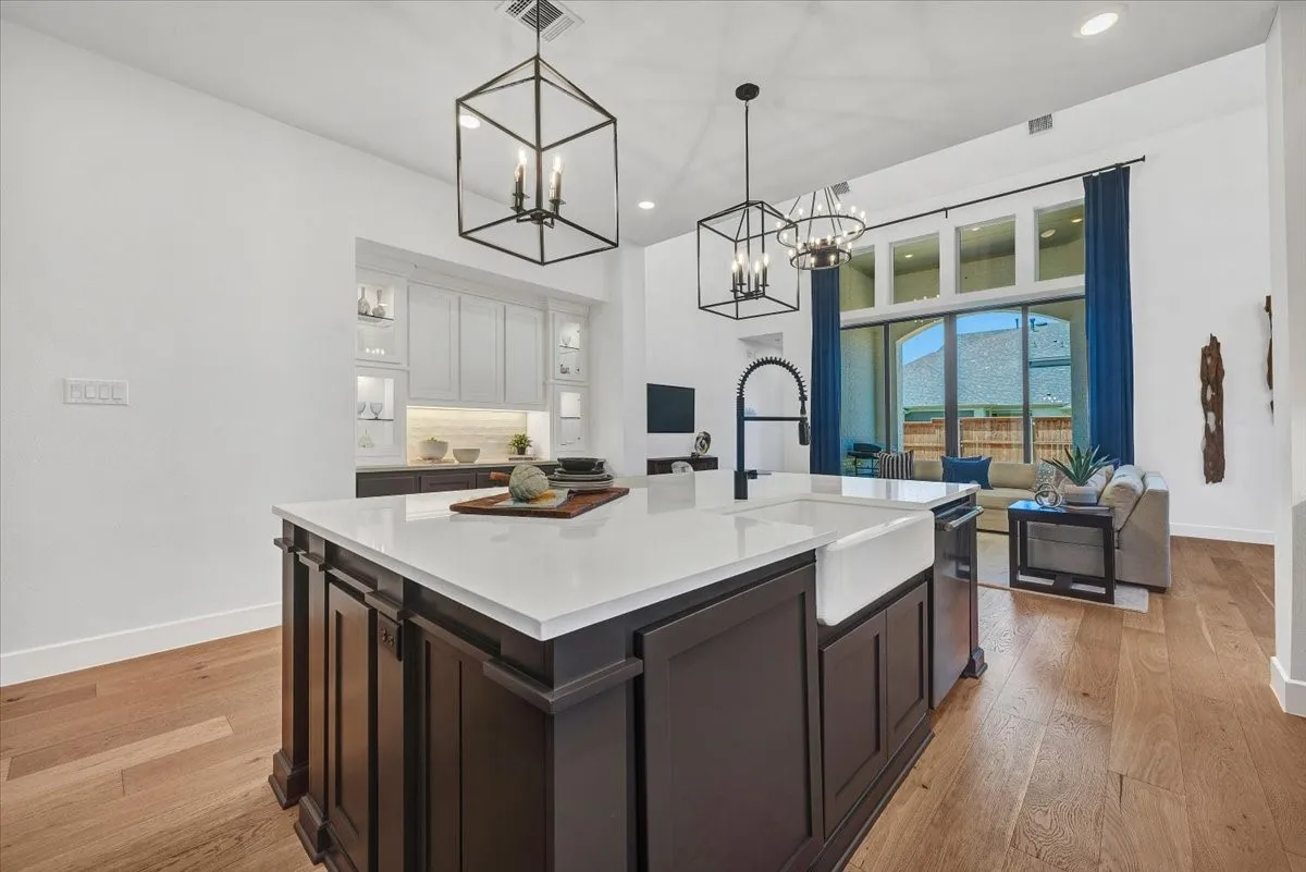 Expansive kitchen island with a white countertop and integrated farmhouse sink