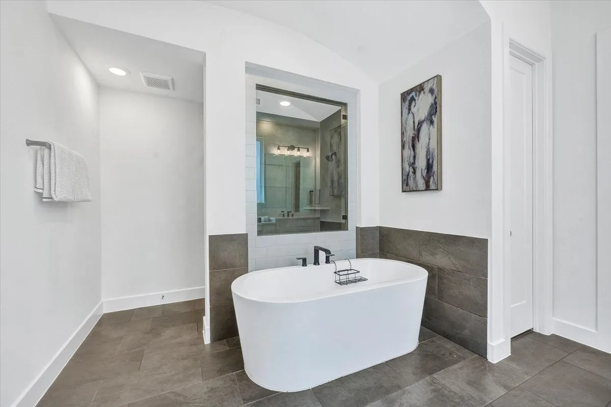 Freestanding soaking tub with dark-finish fixtures