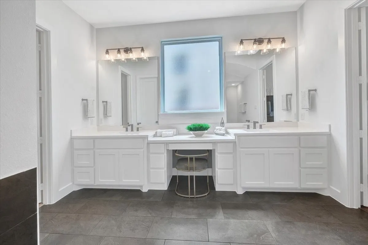 Double vanity featuring white shaker cabinetry, light-toned countertops, and brushed nickel fixtures