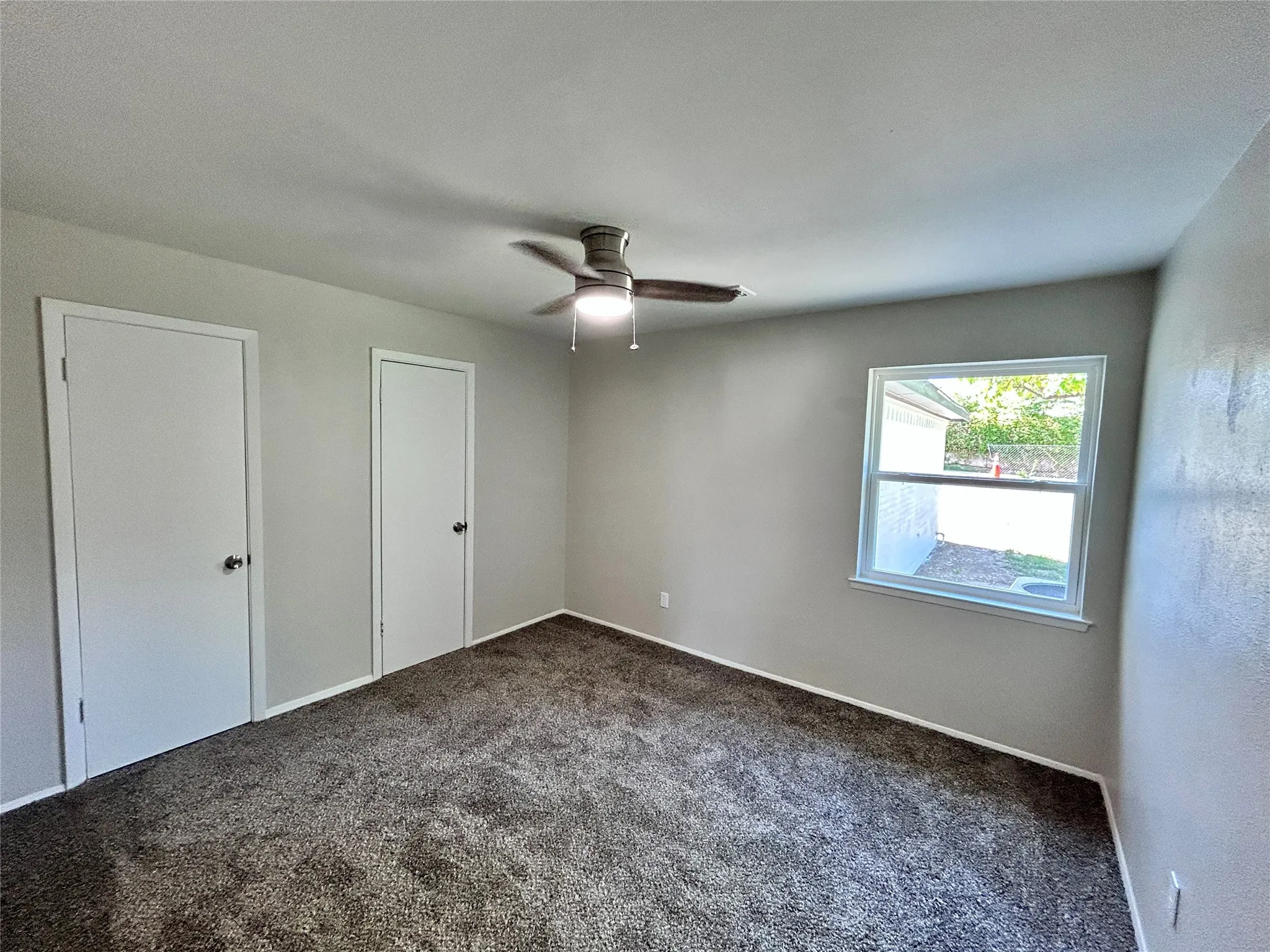 Second bedroom downstairs with ceiling fan and double closet.