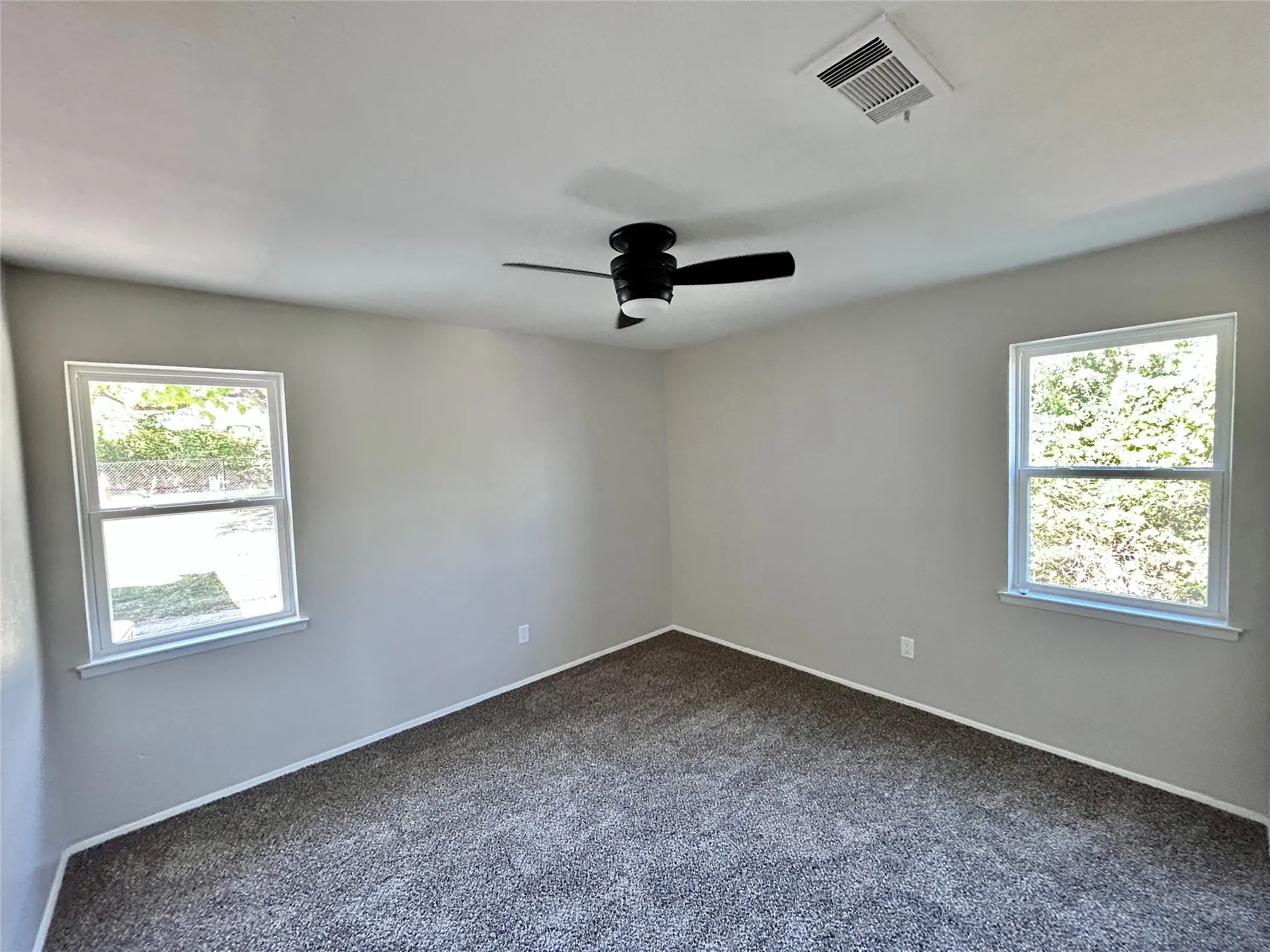 First bedroom downstairs with ceiling fan, and natural light