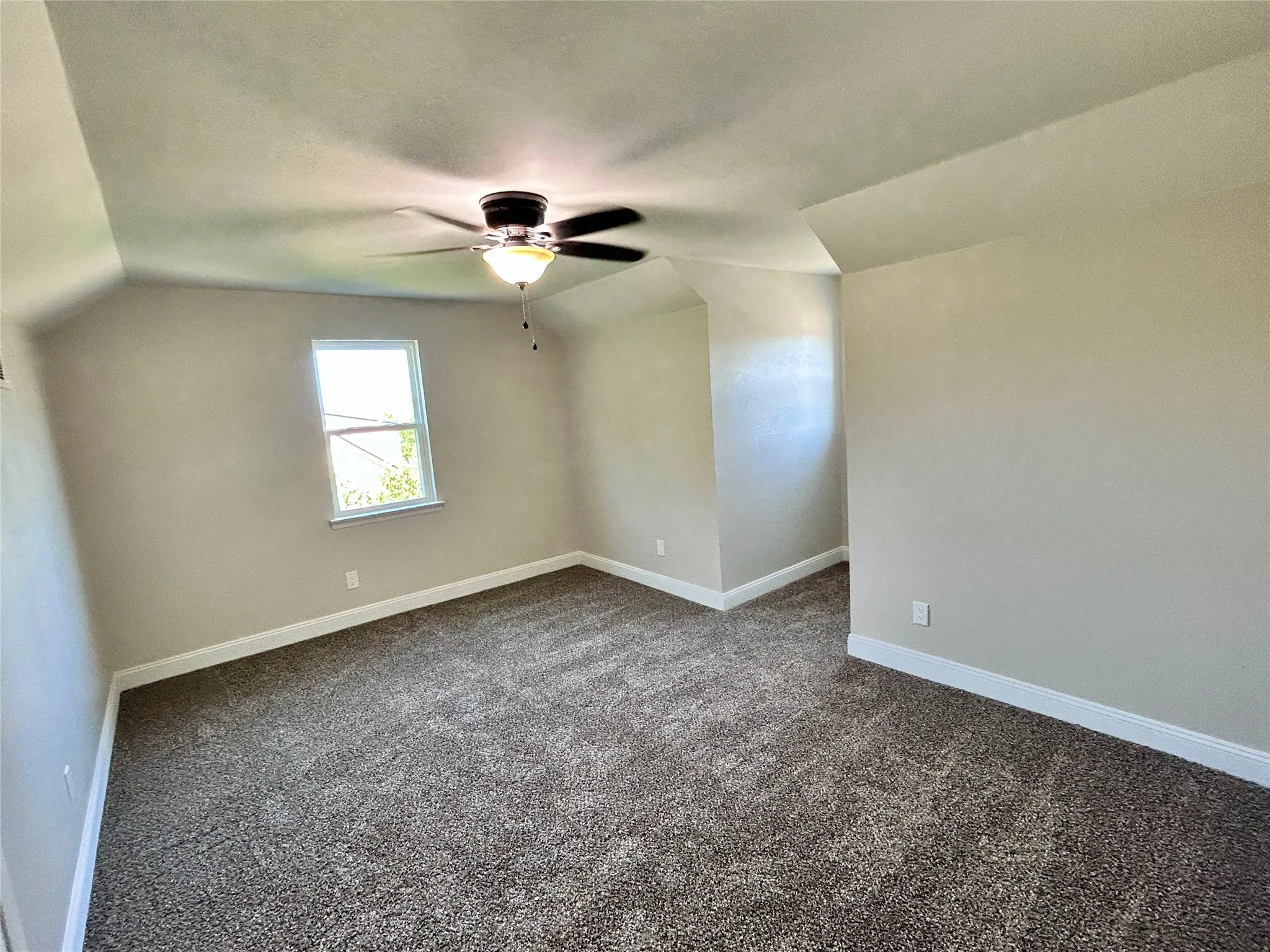 3rd bedroom upstairs with natural light and ceiling fan.