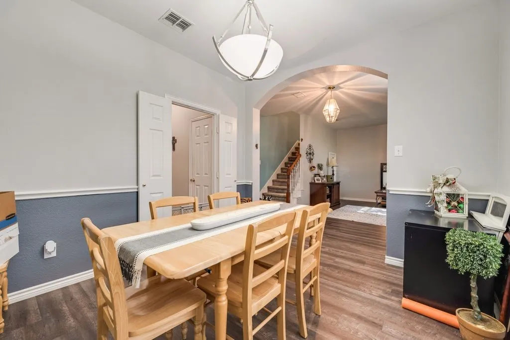 Dining area featuring wood-finish flooring and a contemporary overhead light fixture