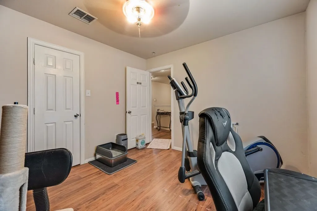 Room featuring wood-finish flooring, light neutral wall paint, and white trim