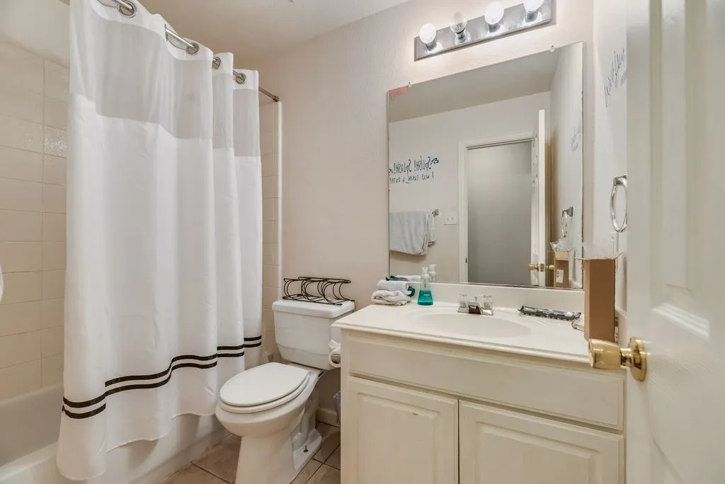 Full bathroom featuring a single vanity, integrated sink, and white cabinet storage