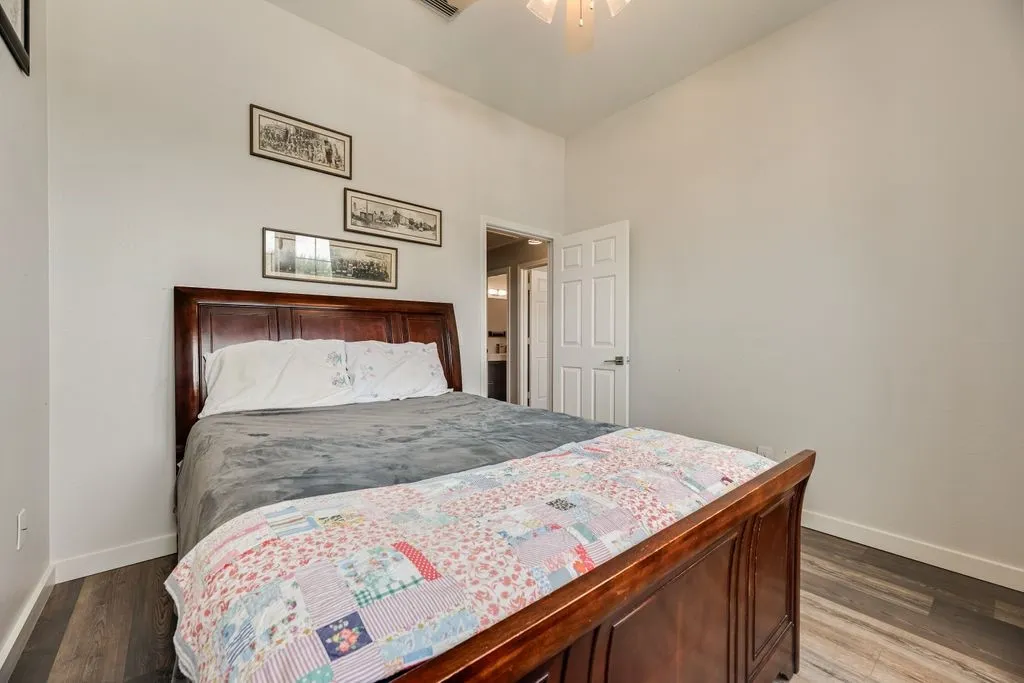 Spacious room with wood-finish flooring, white baseboards, and light-toned walls