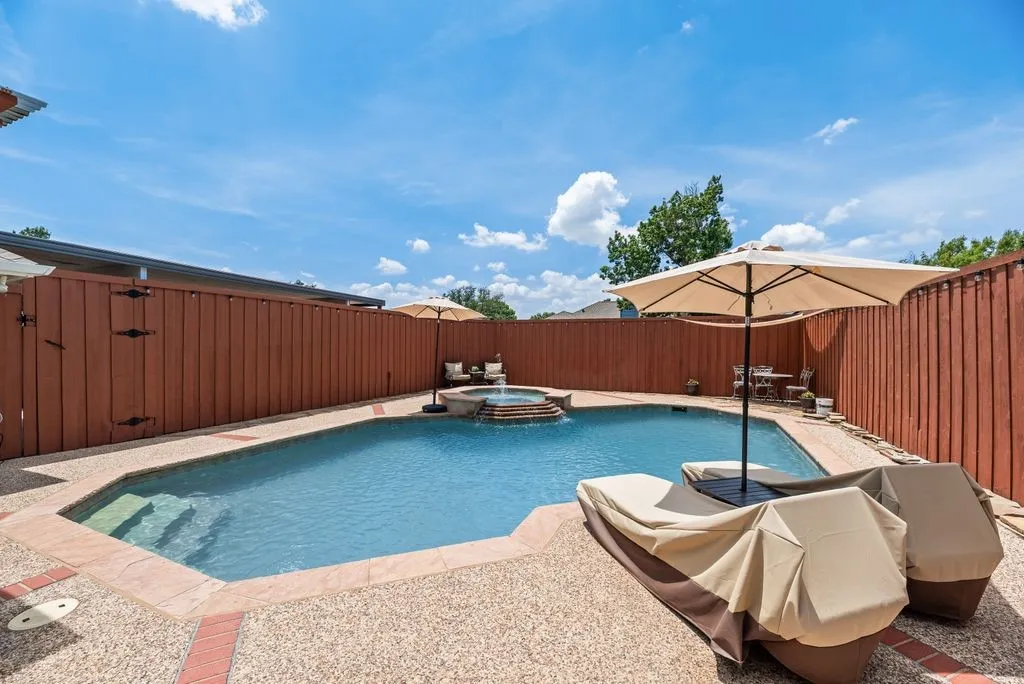 Private backyard featuring a rectangular swimming pool with integrated spa
