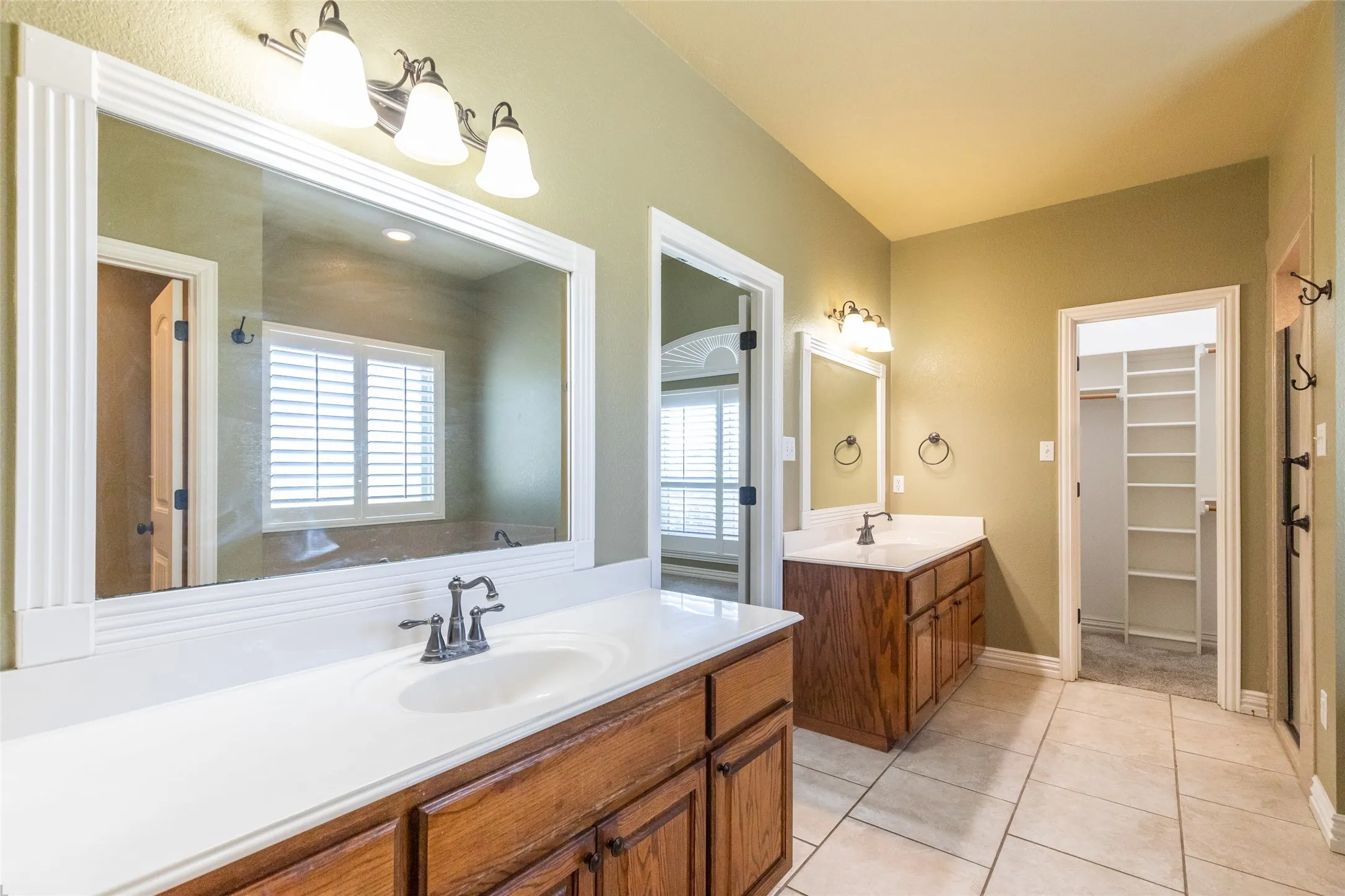 Large primary bath with two separate closets, dual sinks, large walk-in shower and jetted bathtub