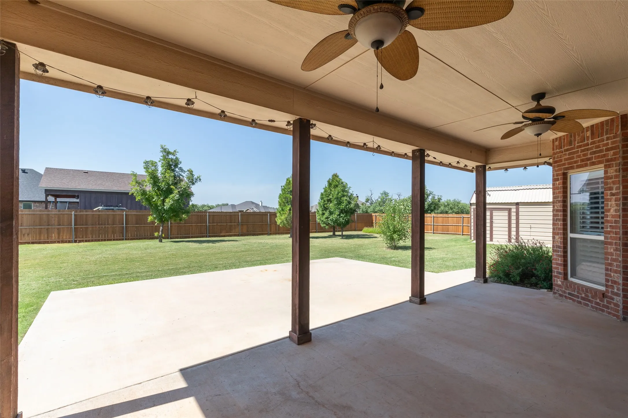 Large covered patio with added concrete extension.   Large shop and storage unit to the right