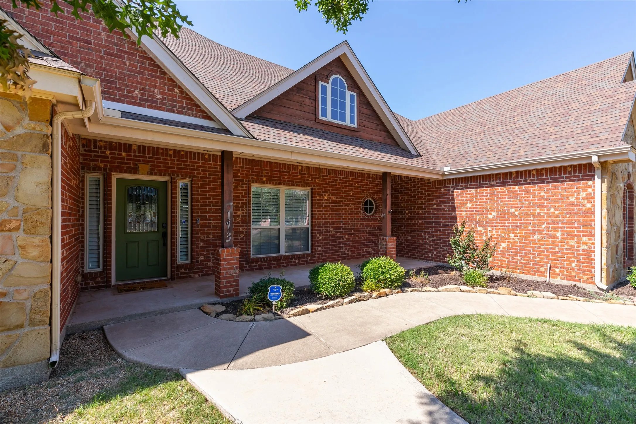 Beautiful entry from the front of the house with sidewalks and a large, covered front porch