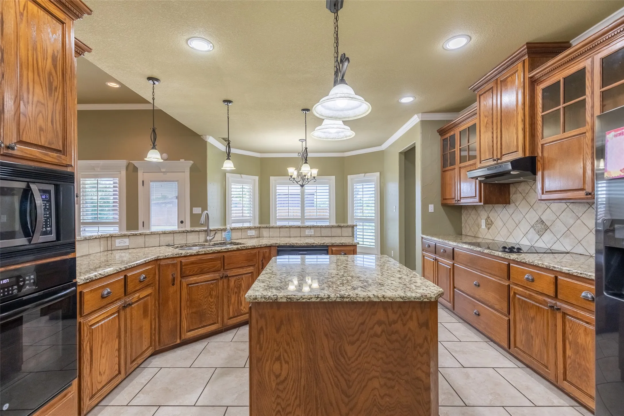 Kitchen with built in oven, granite countertops, microwave, dishwasher and refrigerator. The breakfast room is in the alcove towards the end of the kitchen.  There is ample room for barstools at the kitchen bar area.