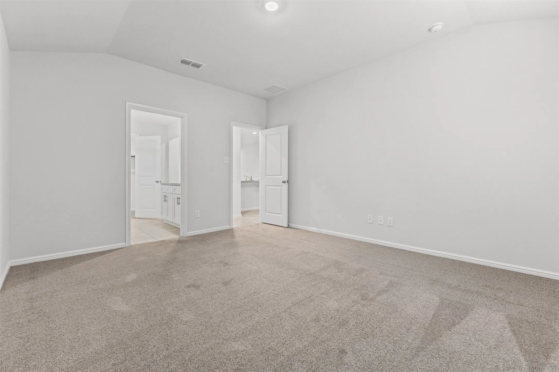 Carpeted room with vaulted ceiling and recessed lighting