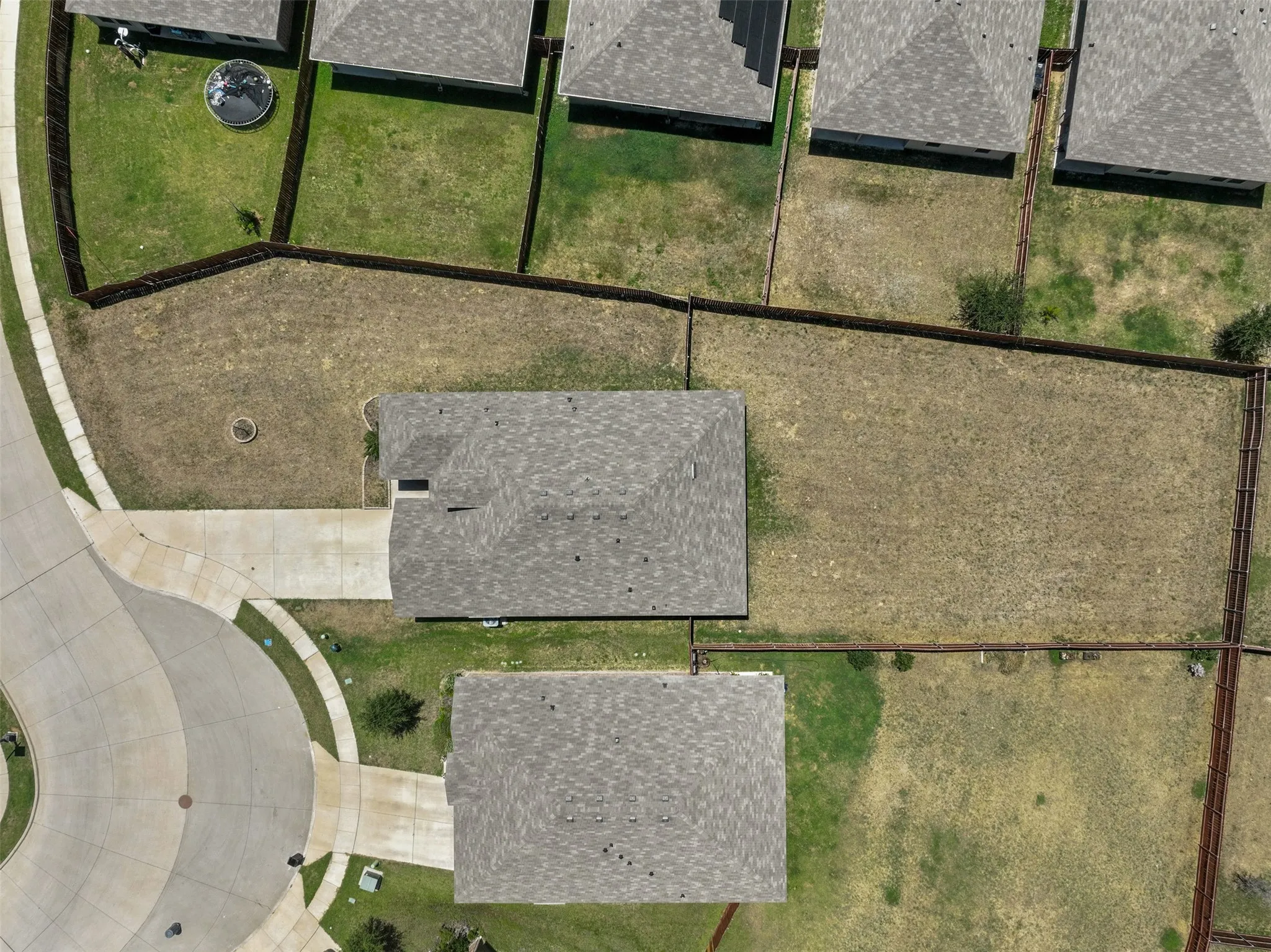 Property featuring a cul-de-sac location, paved driveways, fenced rear yards, and shingled roofing