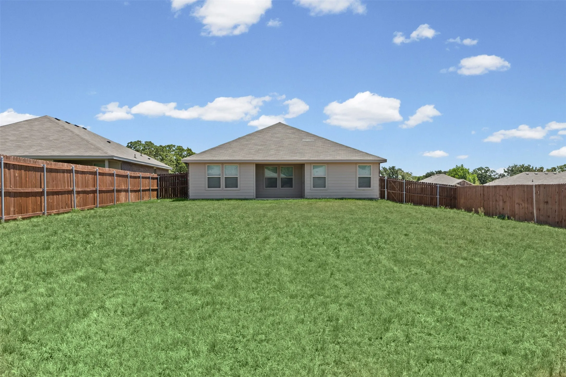 Expansive backyard with a level lawn and perimeter privacy fencing