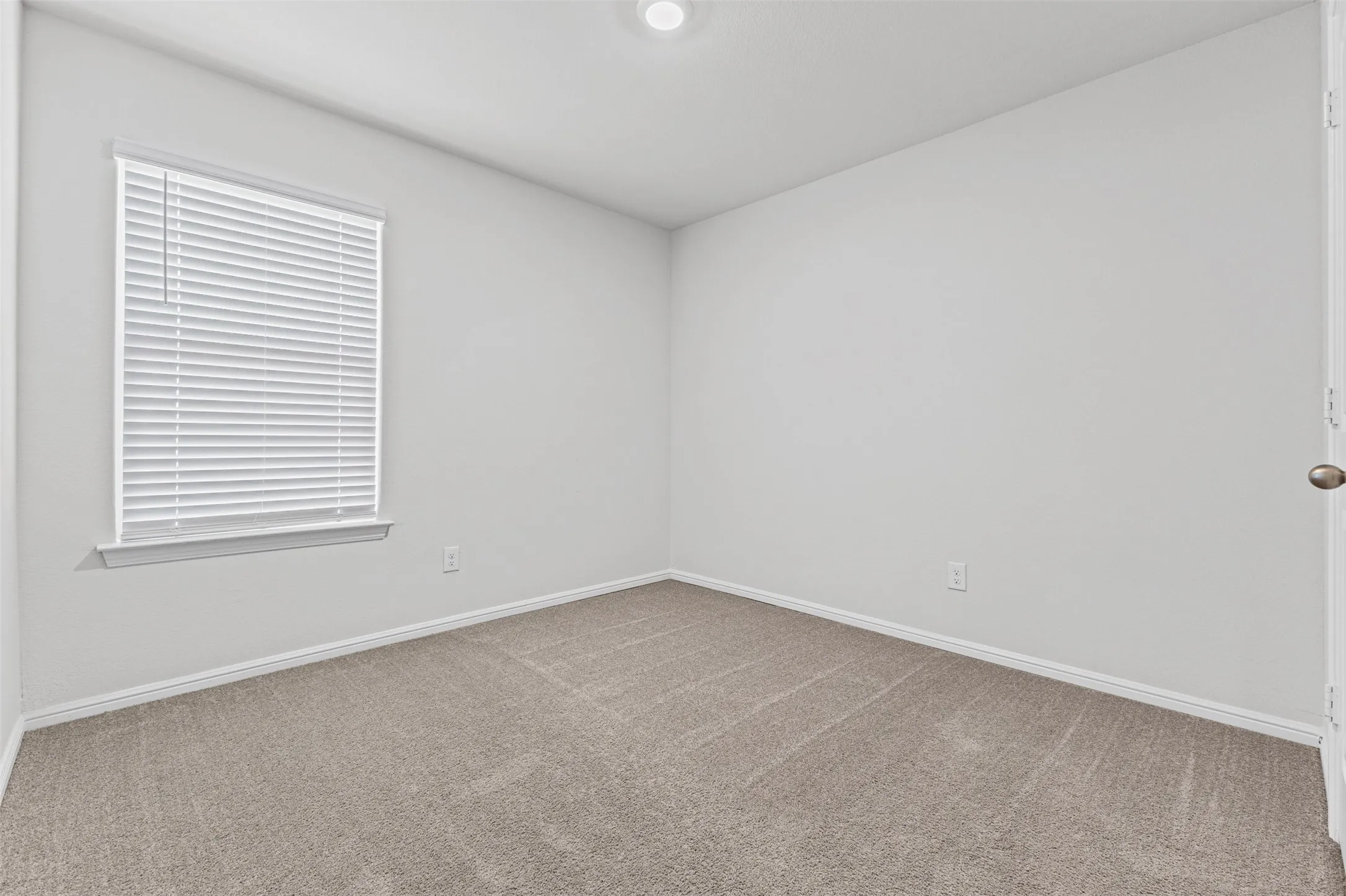 Neutral-toned carpeting paired with light-colored walls and white trim