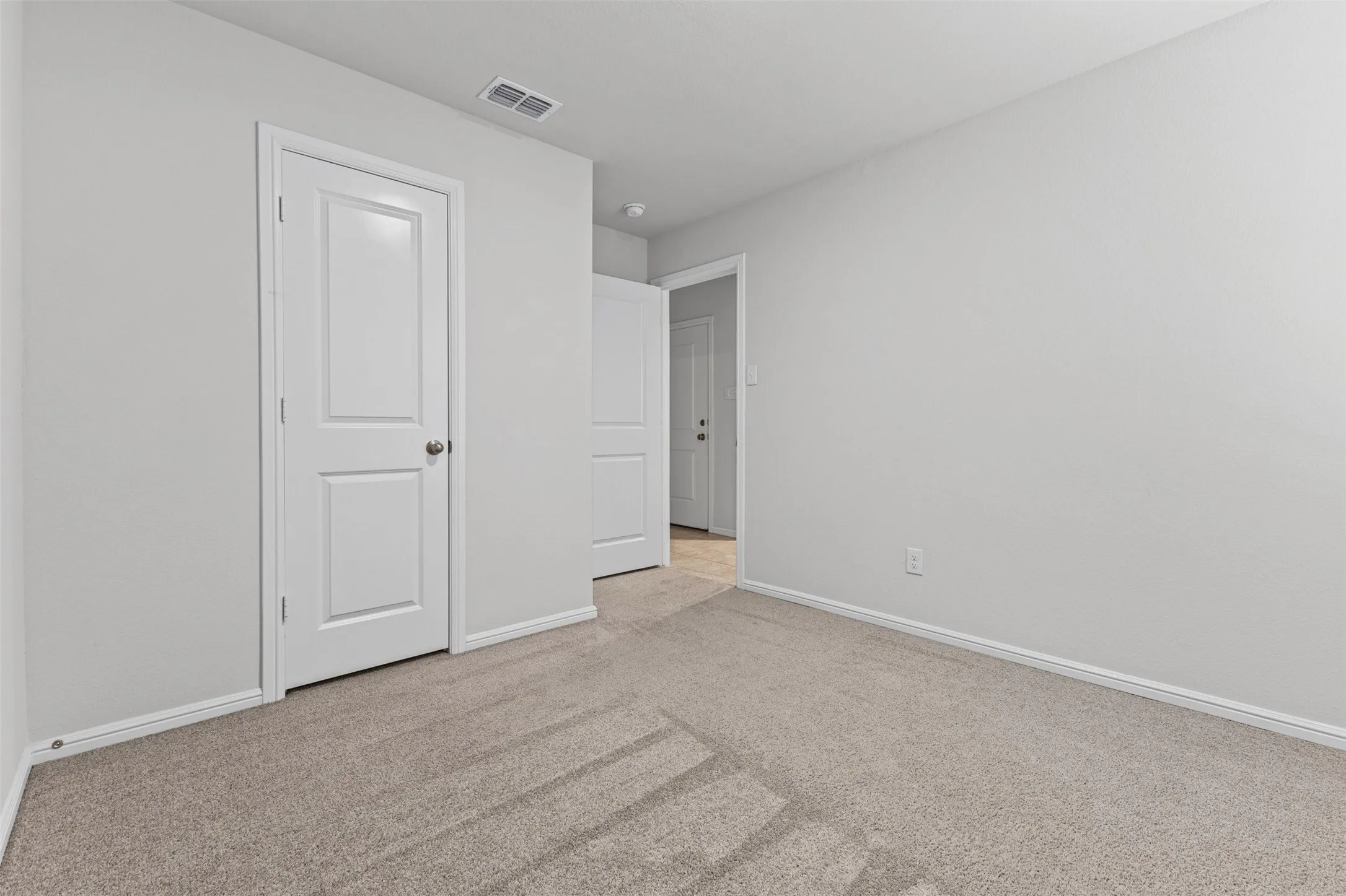 Neutral tone carpeted flooring complements light gray wall finishes