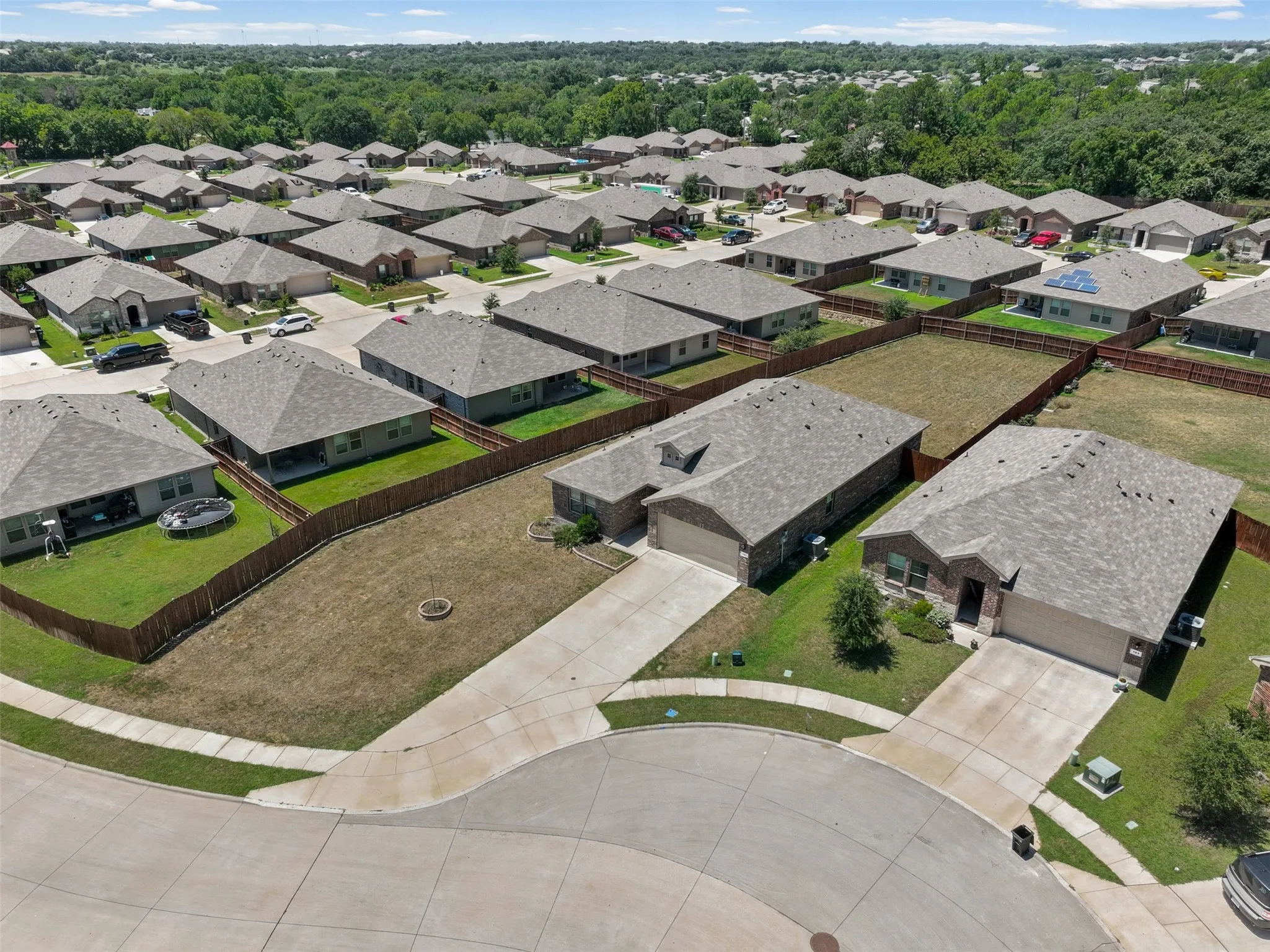 Residential neighborhood featuring single-story homes with shingle roofs and fenced backyards