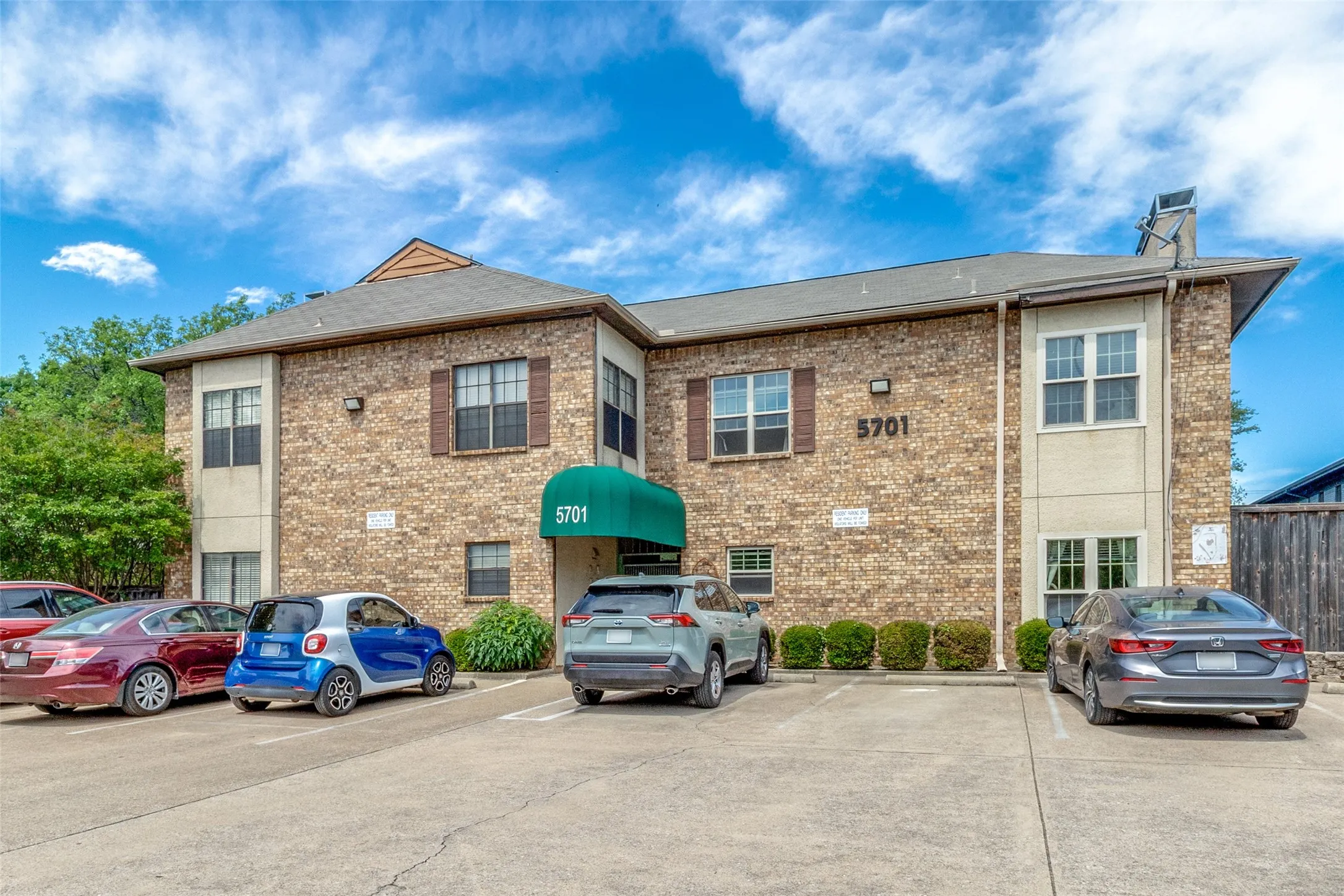 Two-story multi-unit structure featuring a brick facade and tan stucco accents