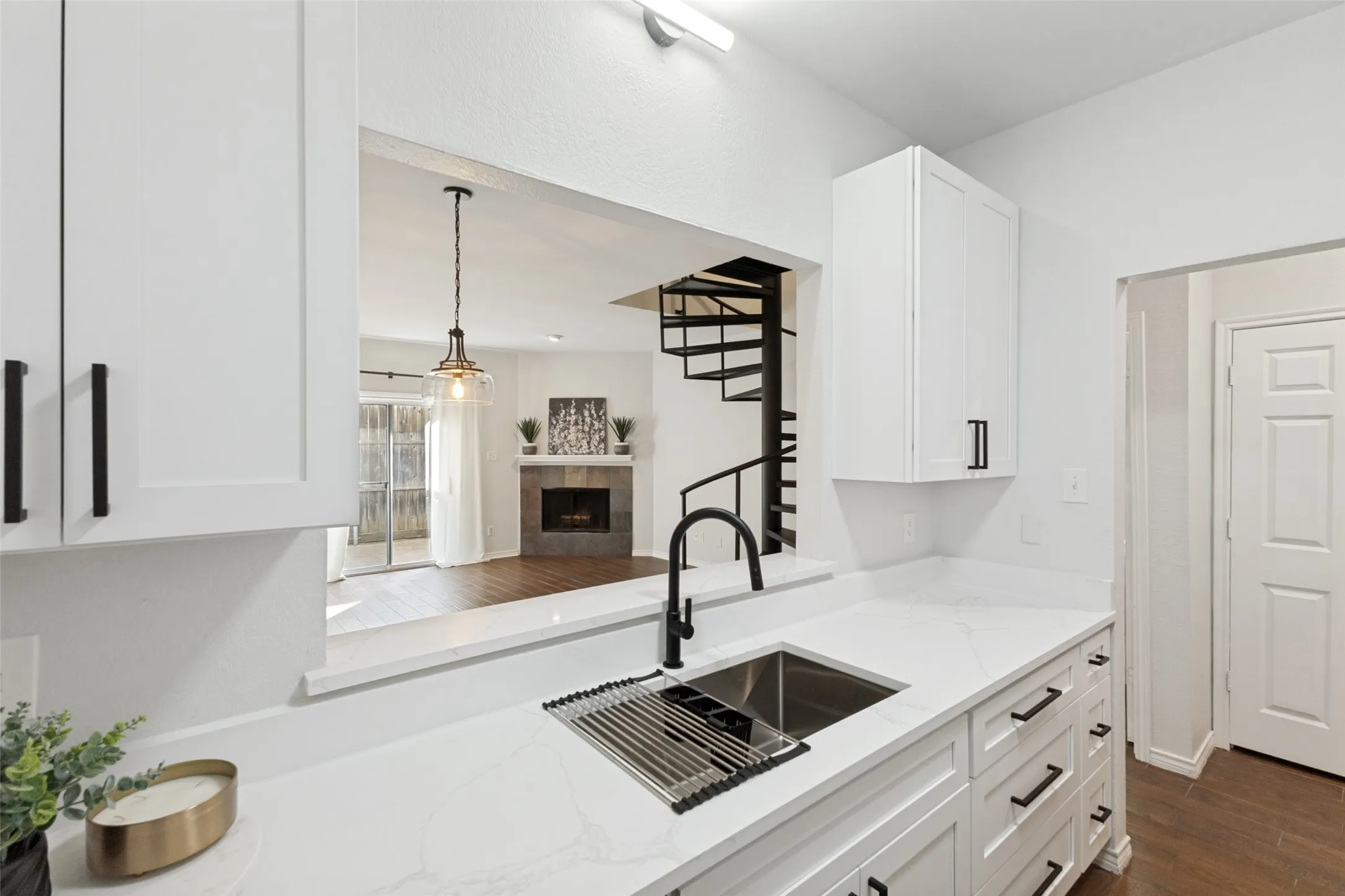 Contemporary kitchen featuring white cabinetry, quartz countertops, a matte black faucet, and a stainless steel undermount sink
