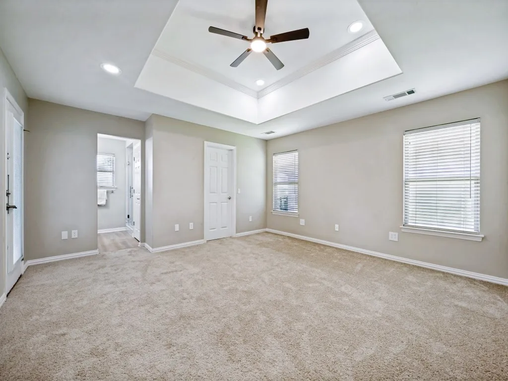 Spacious primary suite has new paint, carpet, and light fixture.
